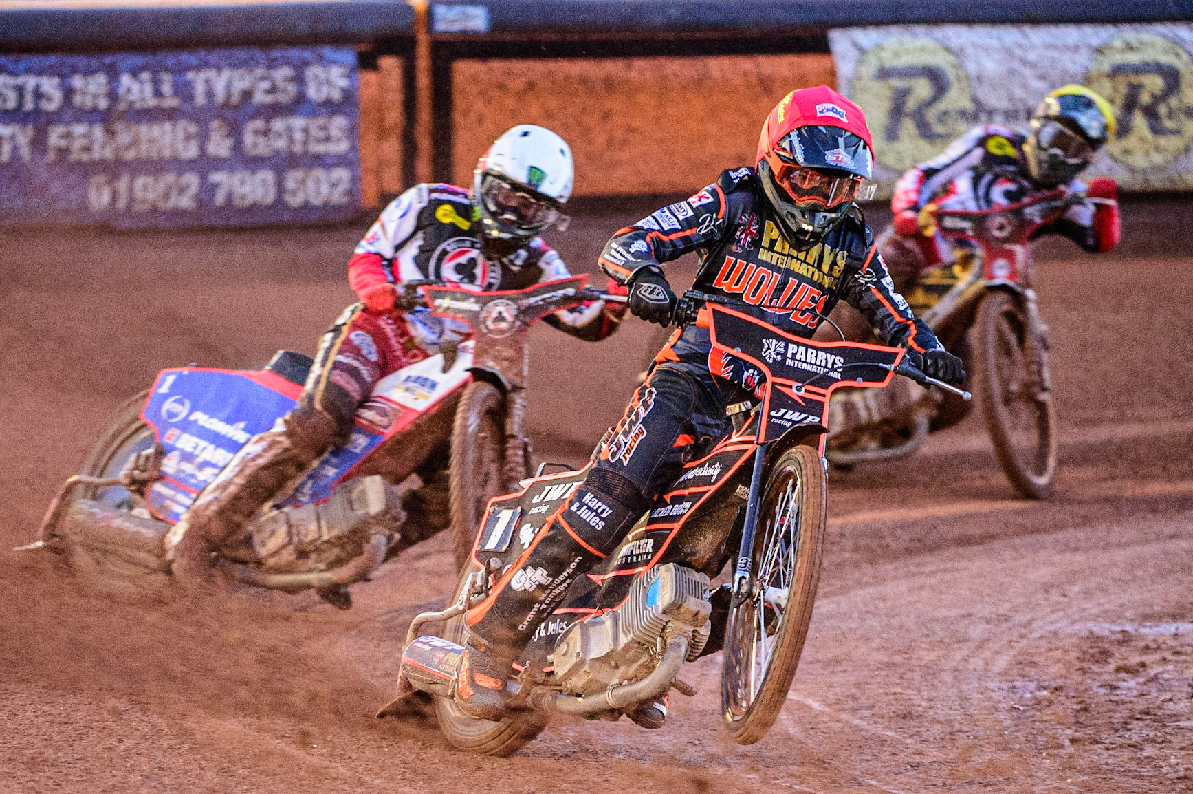 Sam Masters  (Red) picks up some drive ahead of Dan Bewley  (White) and Norick Blodorn  (Yellow) during the SGB Premiership Knock Out Cup Quarter Final 1st Leg between Wolverhampton Wolves and Belle Vue Aces at Monmore Green Stadium, Wolverhampton on Monday 10th April 2023. (Photo: Ian Charles | MI News)
