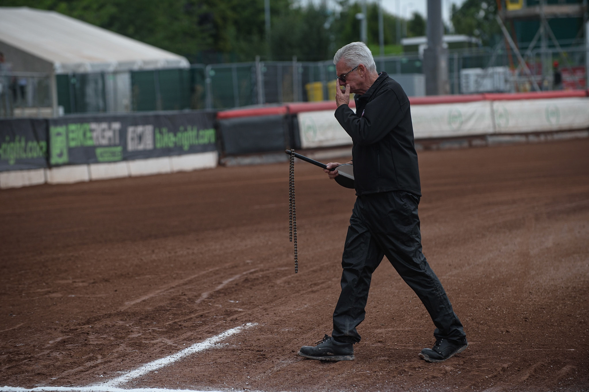 MANCHESTER, UK. AUGUST 30TH After the final heat Start Marshall Ron Shaw retrieves Brady Kurtz broken chain. He picked it on a small pole as the chain was still red hot during the SGB Premiership match between Belle Vue Aces and Wolverhampton Wolves at the National Speedway Stadium, Manchester on Monday 30th August 2021. (Credit: Ian Charles | MI News)