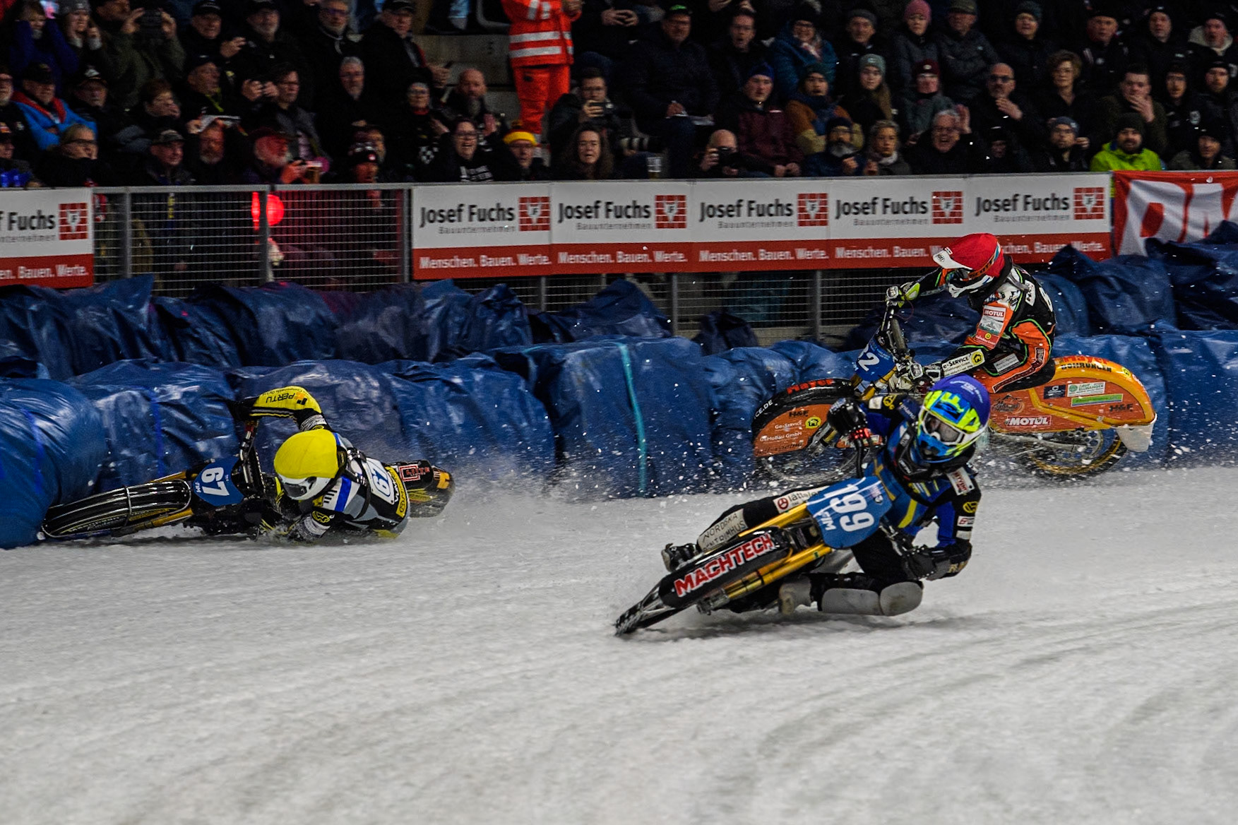 Sweden's Martin Haarahiltunen (199)  (Blue) leads  and Germany's Markus Jell (82) (Red) and Finland's Heikki Huusko (67)y\ collide and crash into the bales during the FIM Ice Speedway Gladiators World Championship Final 2 at the Max-Aicher-Arena, Inzell on Sunday 24 March 2024. (Photo: Ian Charles | MI News)