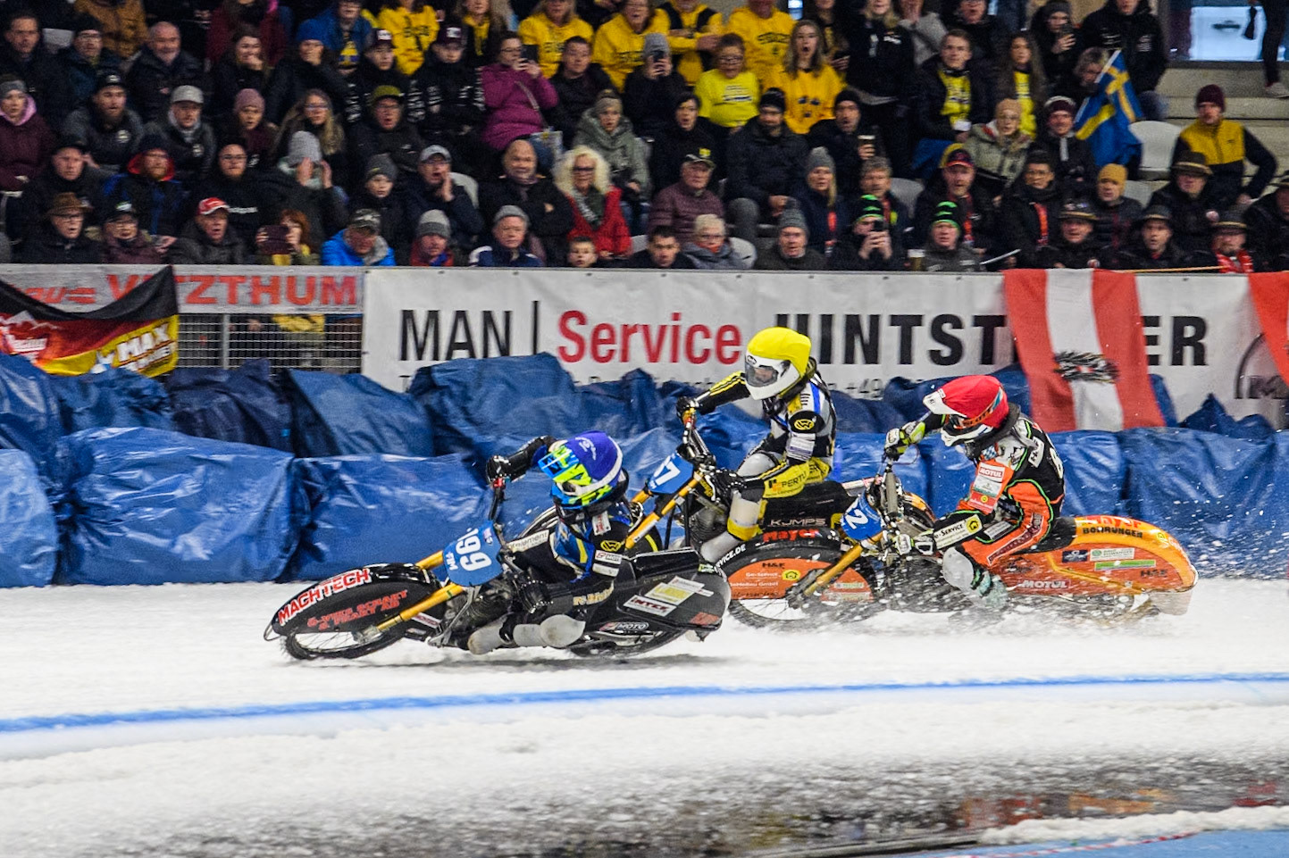 Sweden's Martin Haarahiltunen (199)  (Blue) leads  and Germany's Markus Jell (82) (Red) and Finland's Heikki Huusko (67)y\ collide and crash into the bales during the FIM Ice Speedway Gladiators World Championship Final 2 at the Max-Aicher-Arena, Inzell on Sunday 24 March 2024. (Photo: Ian Charles | MI News)