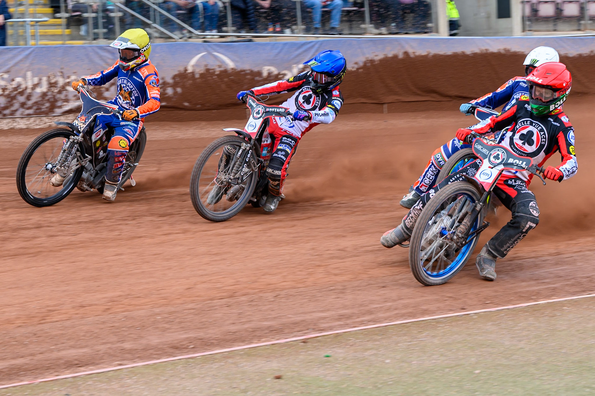 Brady Kurtz of Belle Vue Aces  in Red rides inside Dan Bewley of Belle Vue Aces  in Blue, Nicolai Klindt of Northampton Foxes in Yellow with Jaimon Lidsey of Northampton Foxes  in White behind during the Rowe Motor Oil Premiership match between Belle Vue Aces and Northampton Foxes at the National Speedway Stadium, Manchester on Monday 4th May 2026. (Photo: Ian Charles | MI News)