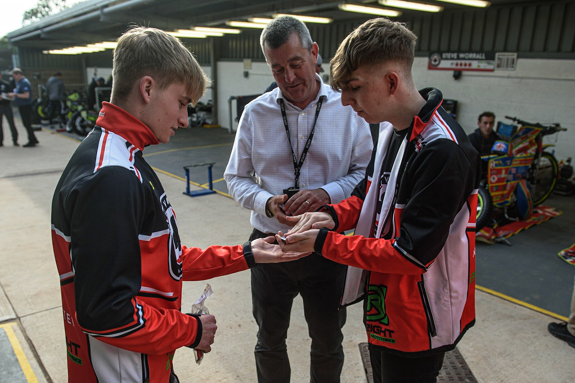 MANCHESTER UKClose up Magician Dan’The Magic Man’ Rhodes does some close up card tricks for Tom Brennan (left) and Belle Vue CEO Adrian Smith during the SGB Premiership match between Belle Vue Aces and Ipswich Witches at the National Speedway Stadium, Manchester on Monday 2nd August 2021. (Credit: Ian Charles | MI News)