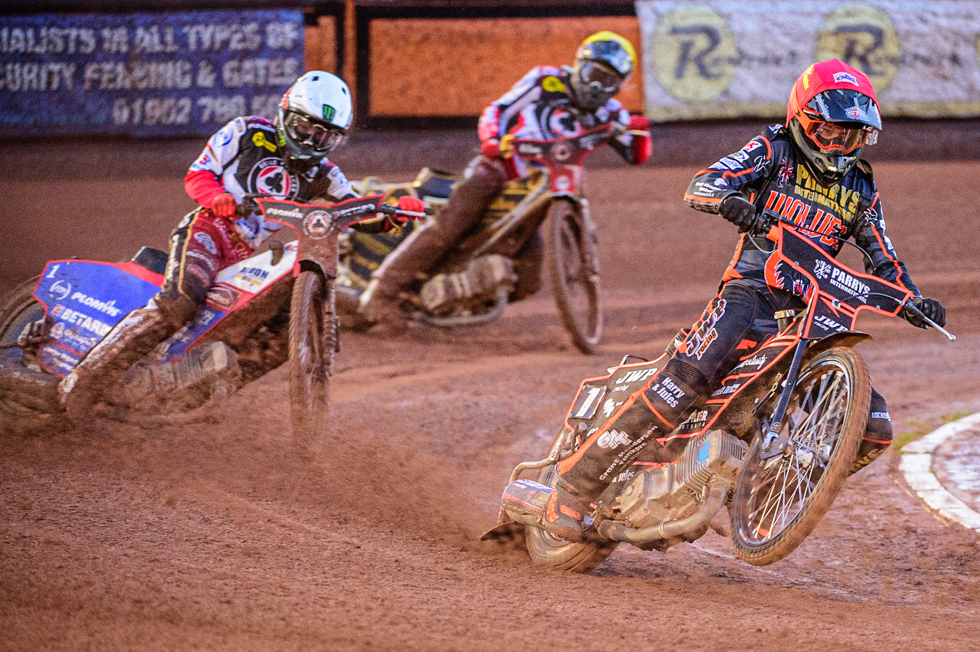 Sam Masters  (Red) picks up some drive ahead of Dan Bewley  (White) and Norick Blodorn  (Yellow) during the SGB Premiership Knock Out Cup Quarter Final 1st Leg between Wolverhampton Wolves and Belle Vue Aces at Monmore Green Stadium, Wolverhampton on Monday 10th April 2023. (Photo: Ian Charles | MI News)