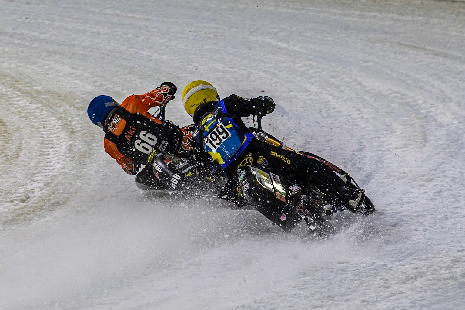 Sweden's Martin Haarahiltunen (199)  in Yellow chases Finland's Aki Ala-Riihimäki (66) in Blue during the FIM Ice Speedway Gladiators World Championship Final 3 at Ice Rink Thialf, Heerenveen on Saturday 6th April 2024. (Photo: Ian Charles | MI News)