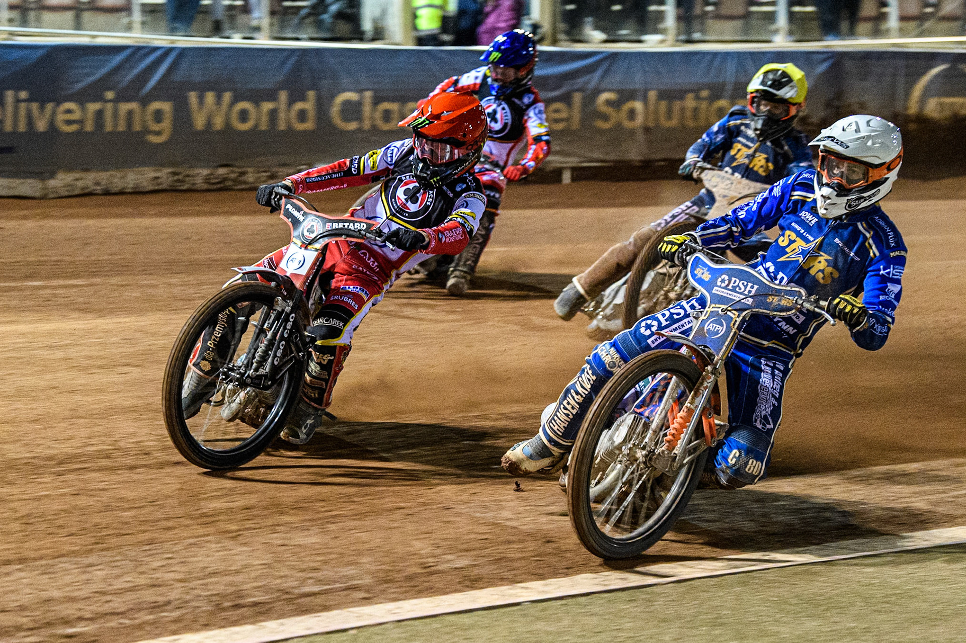 Niels-Kristian Iversen of Kings Lynn Stars in White rides inside Dan Bewley of Belle Vue Aces in Red with Ben Cook of Kings Lynn Stars in White and Jaimon Lidsey of Belle Vue Aces in Blue behind during the Rowe Motor Oil Premiership match between Belle Vue Aces and King's Lynn Stars at the National Speedway Stadium, Manchester on Monday 5th April 2025. (Photo: Ian Charles | MI News)