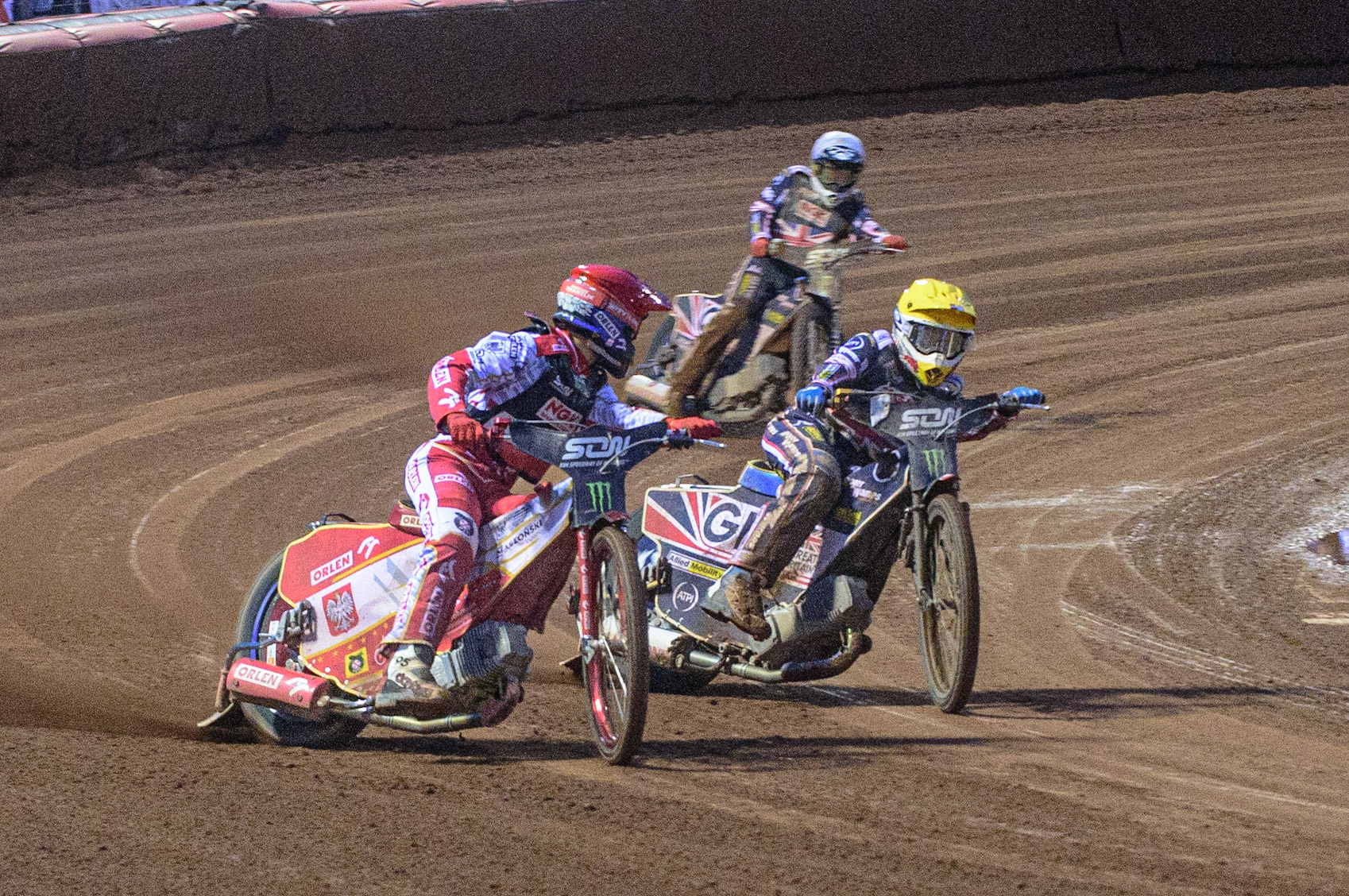 MANCHESTER, UK. OCT 17TH Bartosz Zmarzlik of Poland (Red) looks to find Robert Lambert of Great Britain (Yellow) on his inside and Dan Bewley of Great Britain (White) behind during the Monster Energy FIM Speedway of Nations at the National Speedway Stadium, Manchester on Sunday  17th October 2021. (Credit: Ian Charles | MI News)