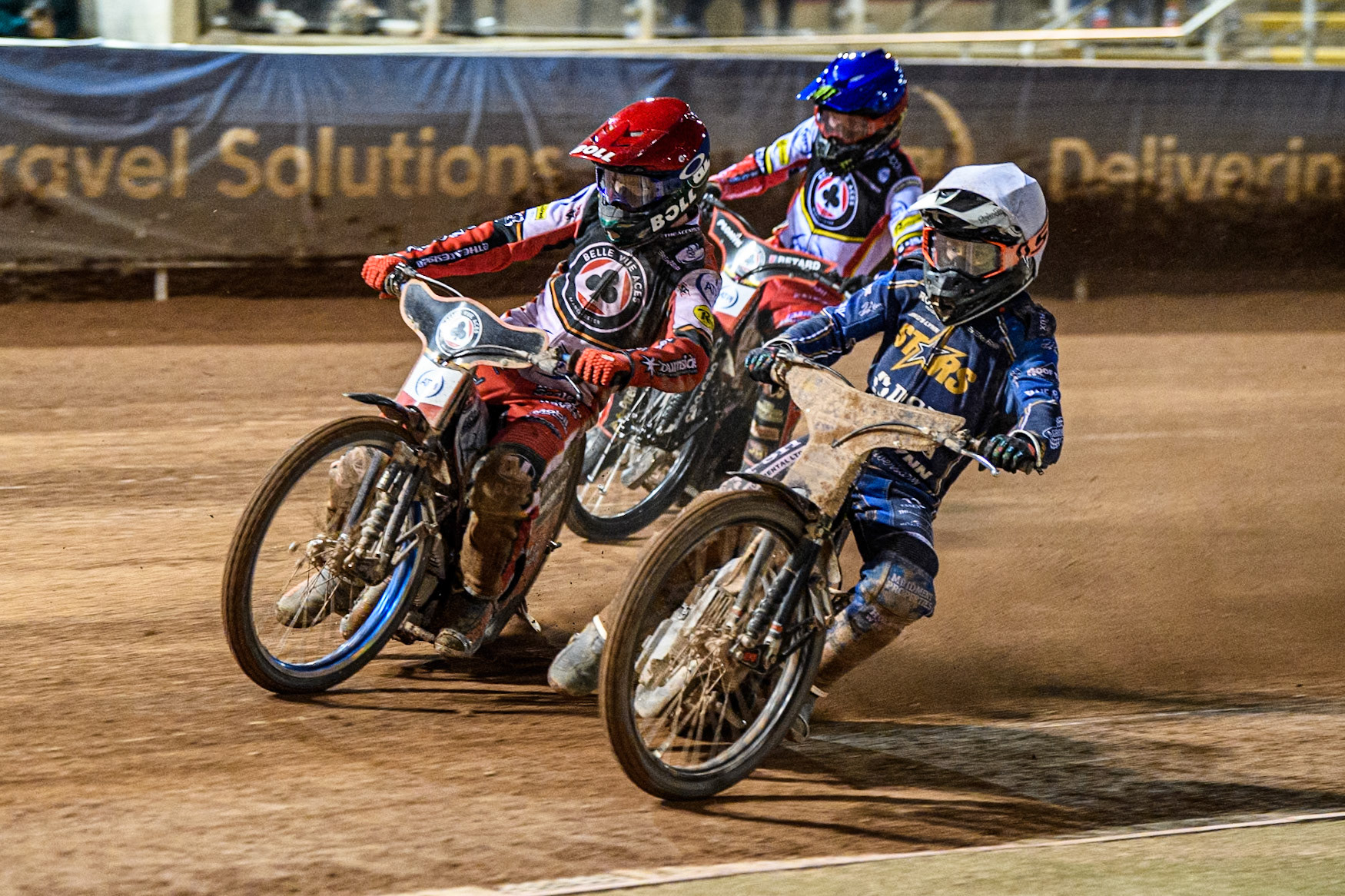 Ben Cook of Kings Lynn Stars in White rides inside Brady Kurtz of Belle Vue Aces in Red with Dan Bewley of Belle Vue Aces in Blue behind during the Rowe Motor Oil Premiership match between Belle Vue Aces and King's Lynn Stars at the National Speedway Stadium, Manchester on Monday 5th April 2025. (Photo: Ian Charles | MI News)