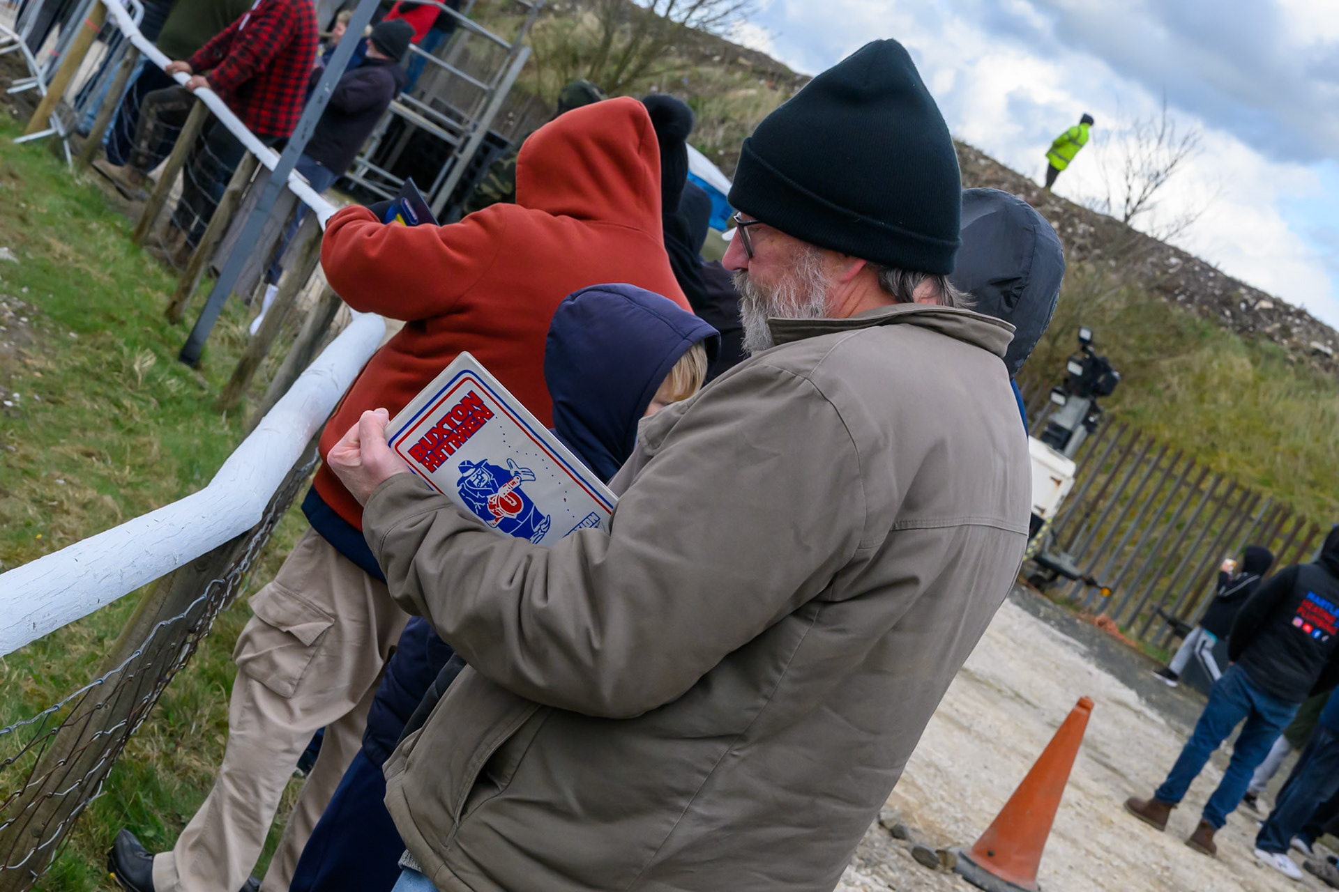 Fan with an old Buxton Hitmen programme board (The Hitmen raced at the Buxton Track from 1994 to 2018) during the Regina Chains Fours at Buxton Speedway, Buxton on Sunday 5th April 2026. (Photo: Ian Charles | MI News)