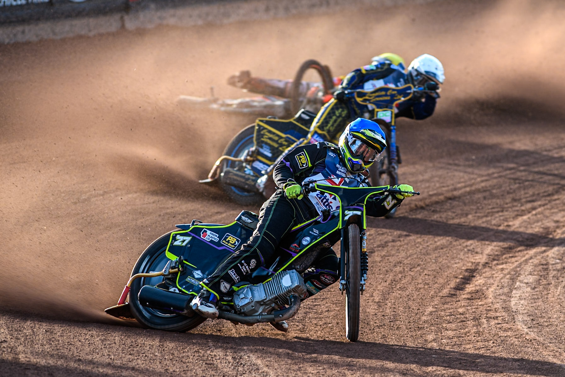 Tom Brennan in Blue leading Kyle Howarth in White as Jordan Jenkins slides off behind during the Attis Insurance Sports Division British Speedway Championship Final at the National Speedway Stadium, Manchester on Saturday 8th June 2024. (Photo: Ian Charles | MI News)