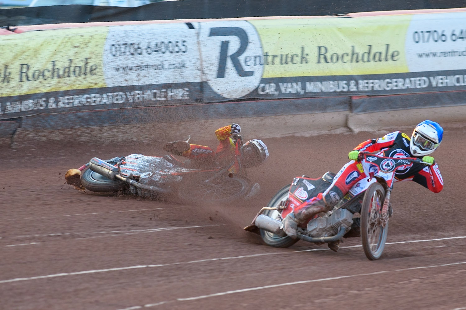 Leicester Lions' Sam Masters in White slides off outside of Belle Vue Aces' Jake Mulford in Blue during the Rowe Motor Oil Premiership match between Belle Vue Aces and Leicester Lions at the National Speedway Stadium, Manchester on Monday 19th May 2025. (Photo: Ian Charles | MI News)