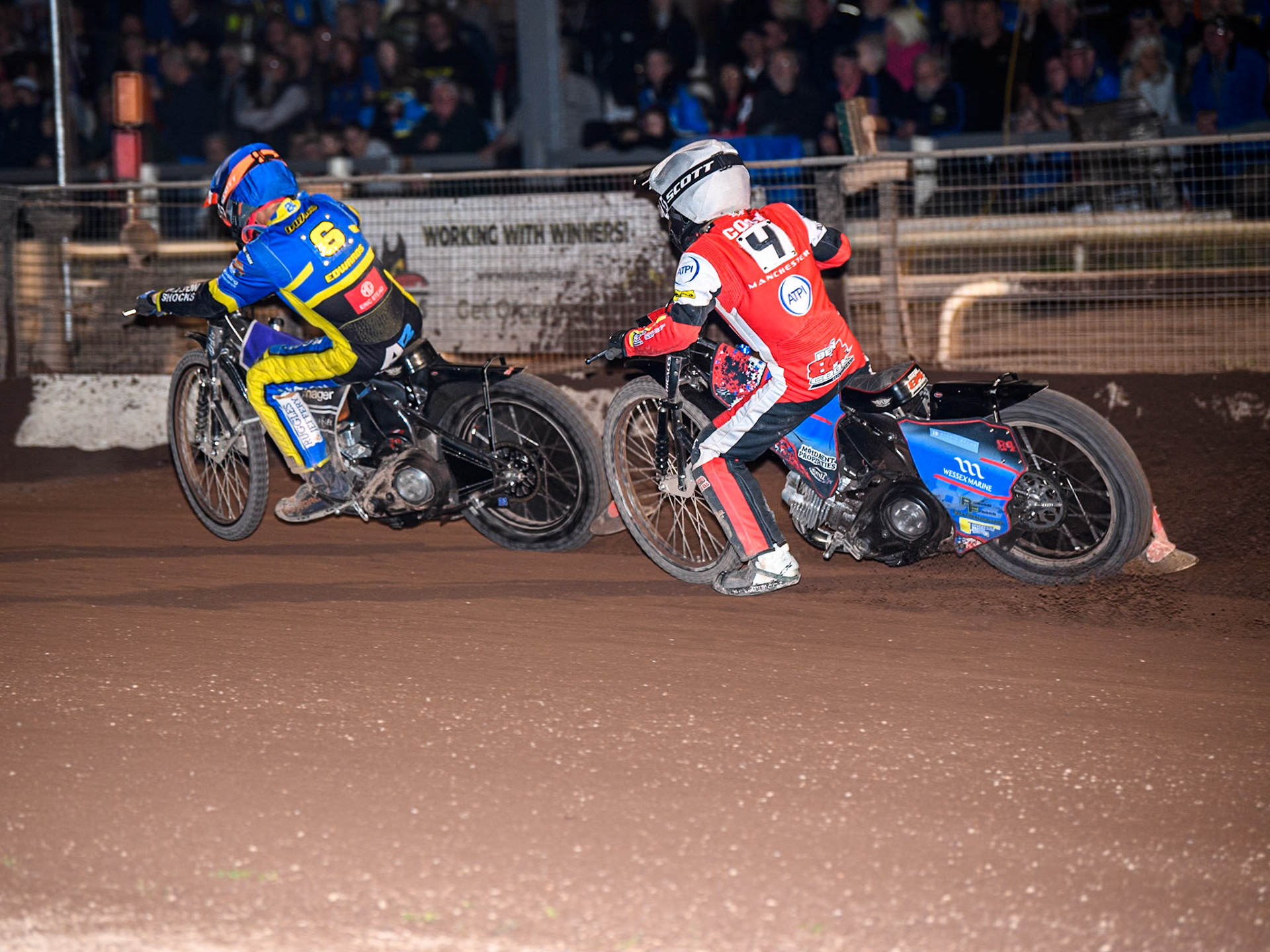 Belle Vue Aces' Ben Cook  in White chases Sheffield Tigers' Jason Edwards  in Blue during the Rowe Motor Oil Premiership match between Sheffield Tigers and Belle Vue Aces at Owlerton Stadium, Sheffield on Monday 26th August 2024. (Photo: Ian Charles | MI News)