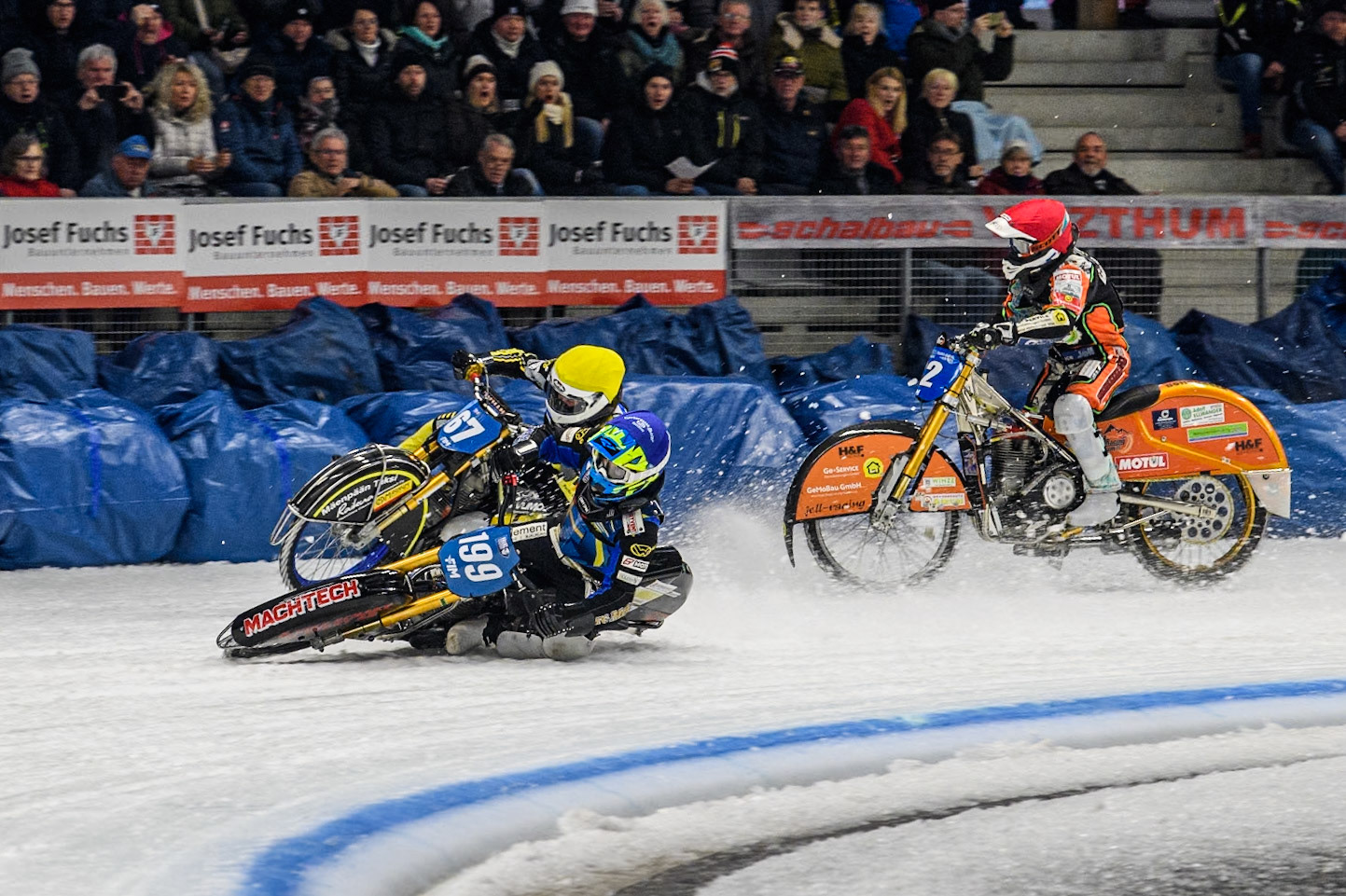 Sweden's Martin Haarahiltunen (199)  (Blue) leads  and Germany's Markus Jell (82) (Red) and Finland's Heikki Huusko (67)y\ collide and crash into the bales during the FIM Ice Speedway Gladiators World Championship Final 2 at the Max-Aicher-Arena, Inzell on Sunday 24 March 2024. (Photo: Ian Charles | MI News)