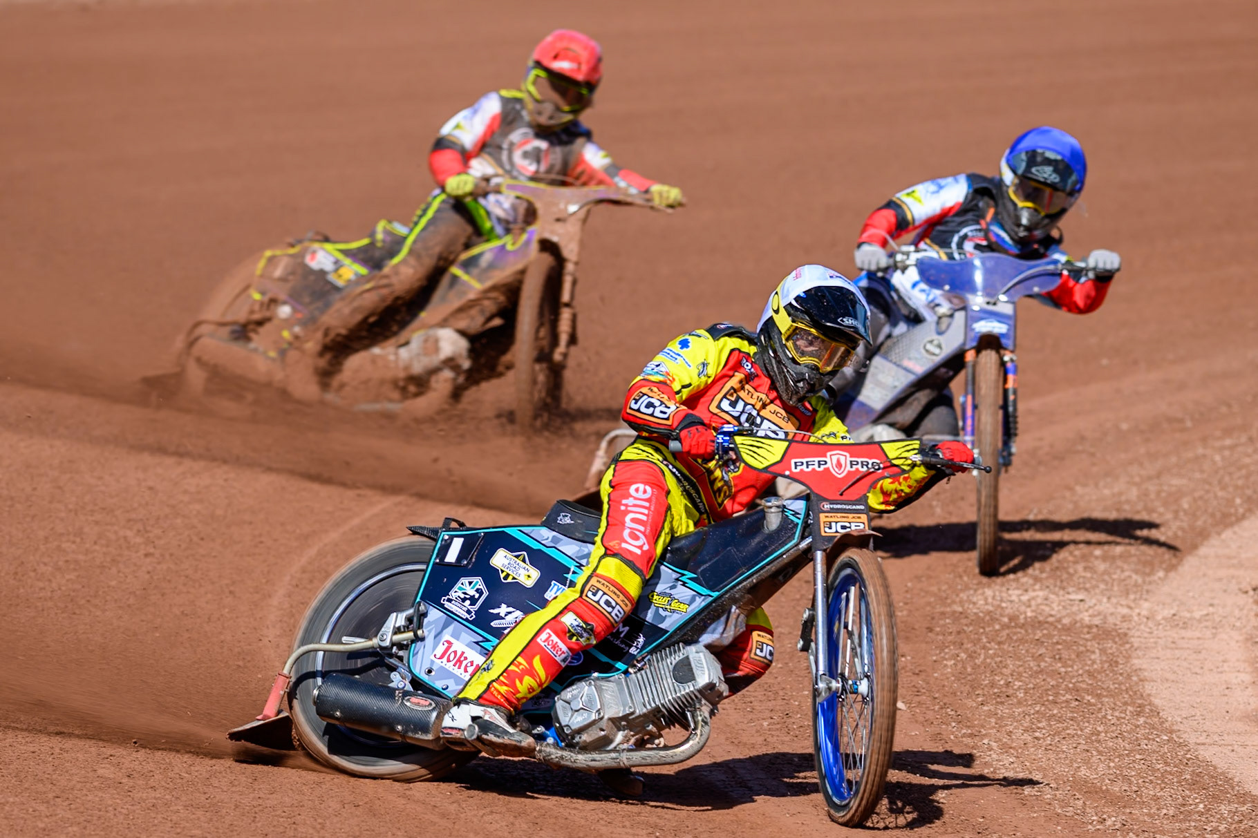 Ryan Douglas of Leicester Lions in White leading Jonas Jeppesen Guest Rider for Belle Vue Aces in Blue and Tom Brennan Guest Rider for Belle Vue Aces  in Red during the Knockout Cup Northern Section match between Belle Vue Aces and Leicester Lions at the National Speedway Stadium, Manchester on Monday 6th April 2026. (Photo: Ian Charles | MI News)