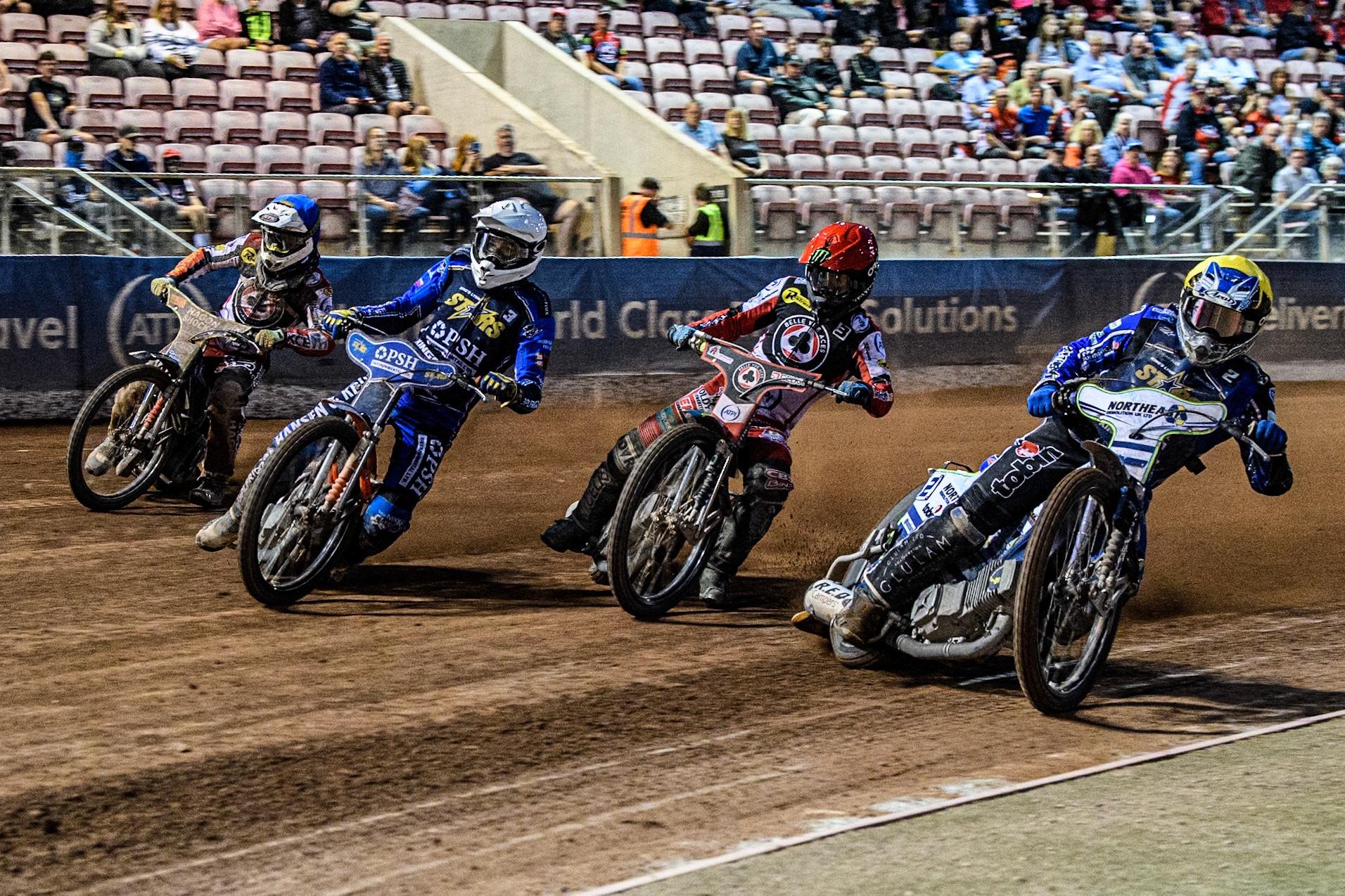 Kings Lynn Stars' Guest Rider Chris Harris  in Yellow and Kings Lynn Stars' Niels-Kristian Iversen  in White take an early lead over Belle Vue Aces' Jaimon Lidsey  in Red and Belle Vue Aces' Jake Mulford  in Blue during the Rowe Motor Oil Premiership match between Belle Vue Aces and King's Lynn Stars at the National Speedway Stadium, Manchester on Monday 12th August 2024. (Photo: Ian Charles | MI News)