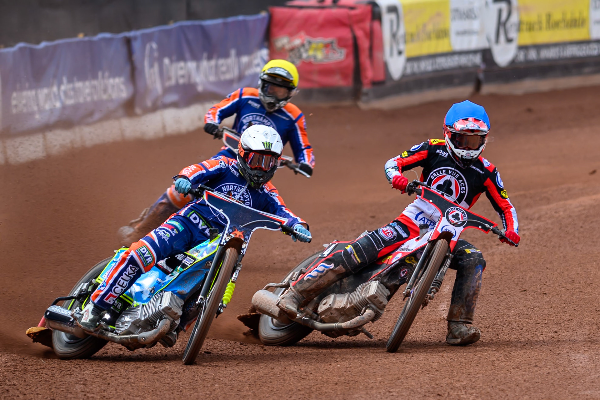 Jaimon Lidsey of Northampton Foxes in White rides outside Zach Cook of Belle Vue Aces in Blue with Troy Batchelor of Northampton Foxes in Yellow behind during the Rowe Motor Oil Premiership match between Belle Vue Aces and Northampton Foxes at the National Speedway Stadium, Manchester on Monday 4th May 2026. (Photo: Ian Charles | MI News)