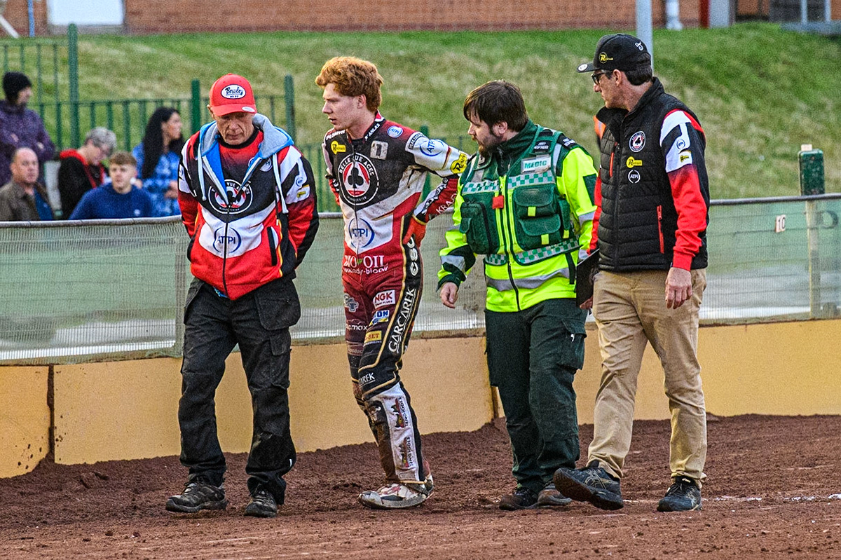 Dan Bewley (2nd left) walks back to the pits after his fall with (l - r) Dad, Neil Bewley, Dan Bewley , Paramedic, \and team manager Mark Lemon during the Sports Insure Premiership match between Wolverhampton Wolves and Belle Vue Aces at Monmore Green Stadium, Wolverhampton on Monday 10th July 2023. (Photo: Ian Charles | MI News)