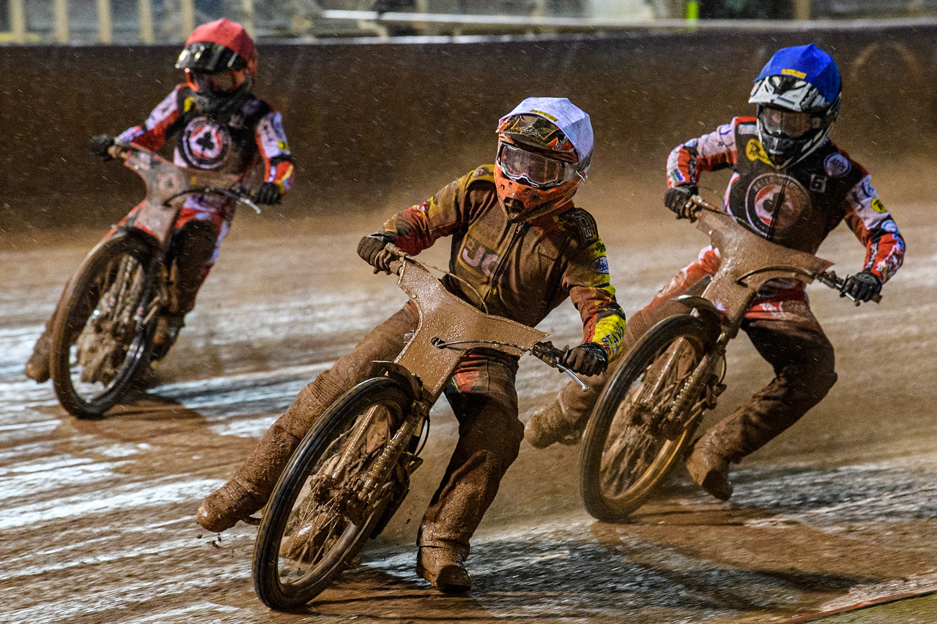 Luke Becker of Leicester Lions in White leading Ben Cook of Belle Vue Aces in Red and Connor Mountain of Belle Vue Aces in Blue during the Rowe Motor Oil Premiership match between Belle Vue Aces and Leicester Lions at the National Speedway Stadium, Manchester on Saturday 6th April 2024. (Photo: Ian Charles | MI News)