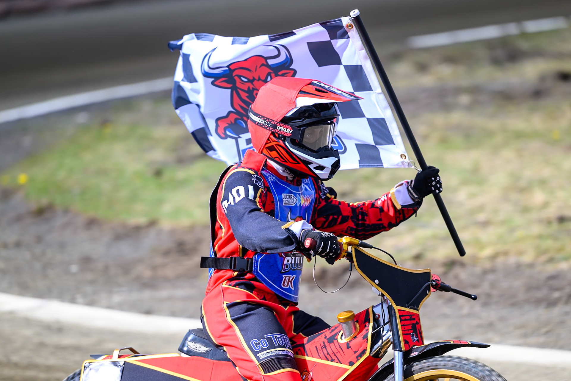 Luke Harris of Buxton Bulls   celebrates his win with the Bulls Flag as he rides along the home straight during the  Challenge match between Buxton Bulls and NDL Nomads at Hi-Edge Speedway, Buxton on Sunday 19th April 2026. (Photo: Ian Charles | MI News)