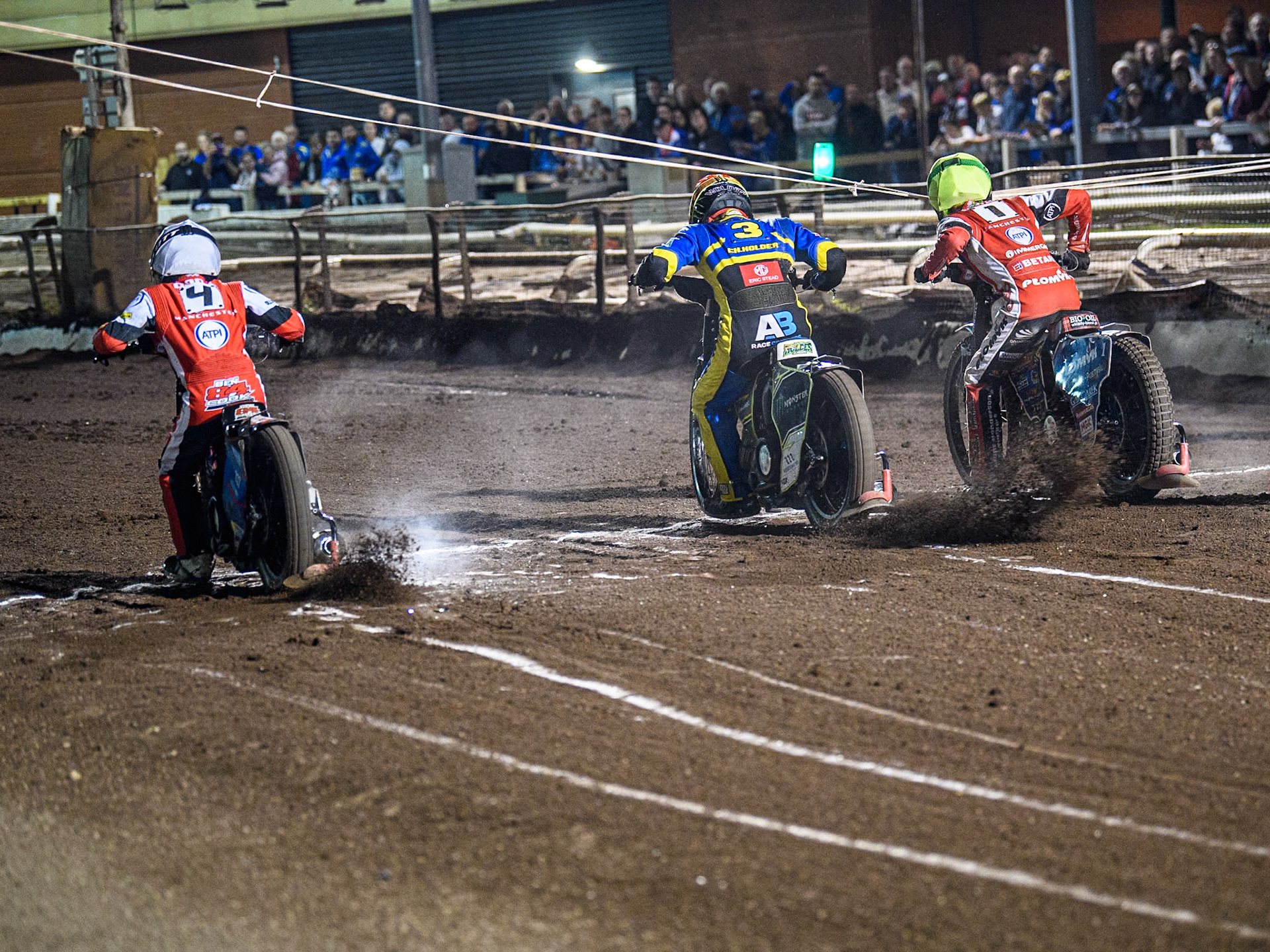 Belle Vue Aces' Dan Bewley   in Yellow catches his helmet peak on the starting tapes, with Sheffield Tigers' Chris Holder  in Red and Belle Vue Aces' Ben Cook  in White on his inside during the Rowe Motor Oil Premiership match between Sheffield Tigers and Belle Vue Aces at Owlerton Stadium, Sheffield on Monday 26th August 2024. (Photo: Ian Charles | MI News)