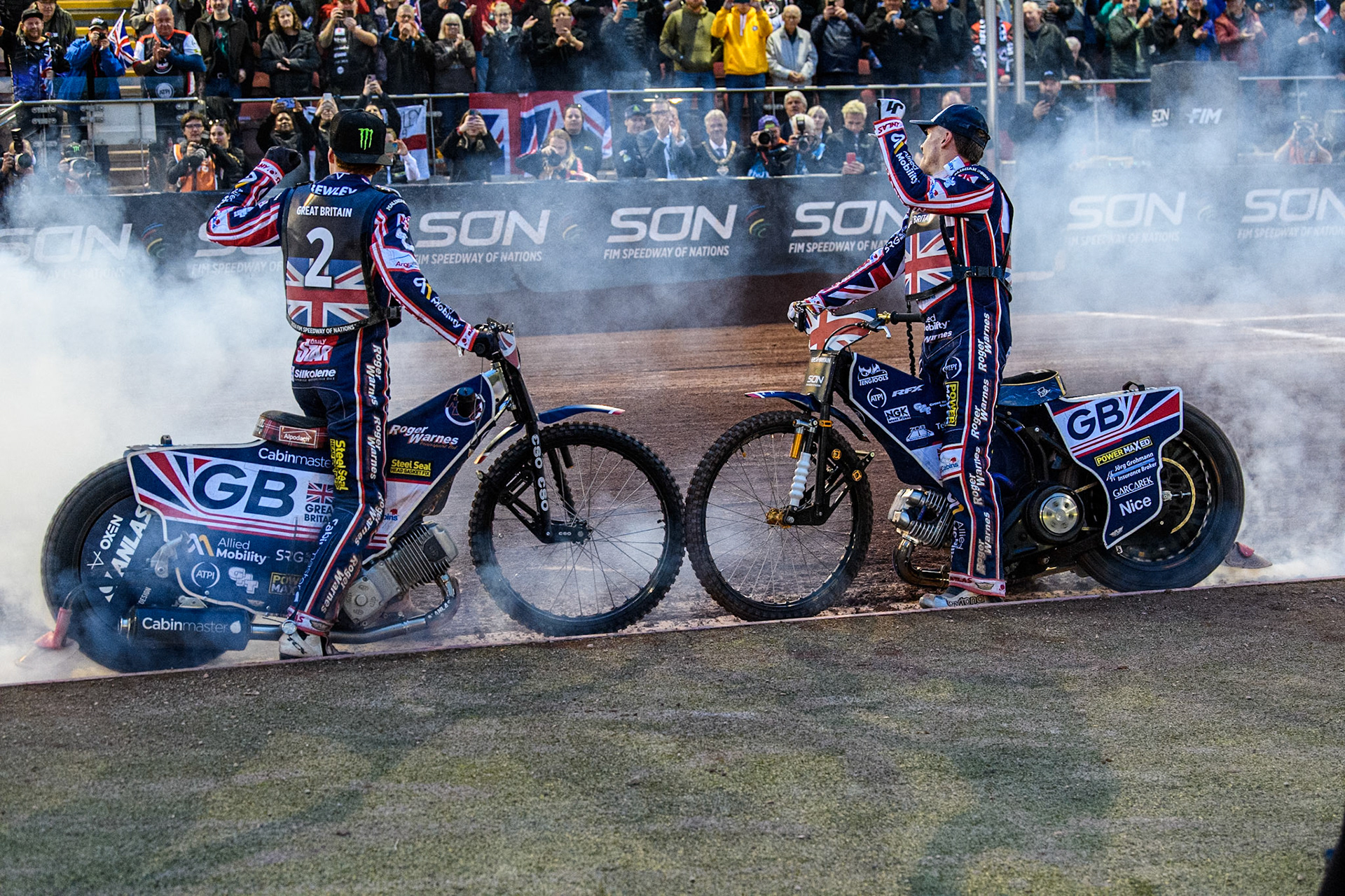 Dan Bewley of Great Britain (Left) and Robert Lambert of Great Britain celebrate with a dual burn out during the Monster Energy FIM Speedway of Nation Final at the National Speedway Stadium, Manchester on Saturday 13th July 2024. (Photo: Ian Charles | MI News)
