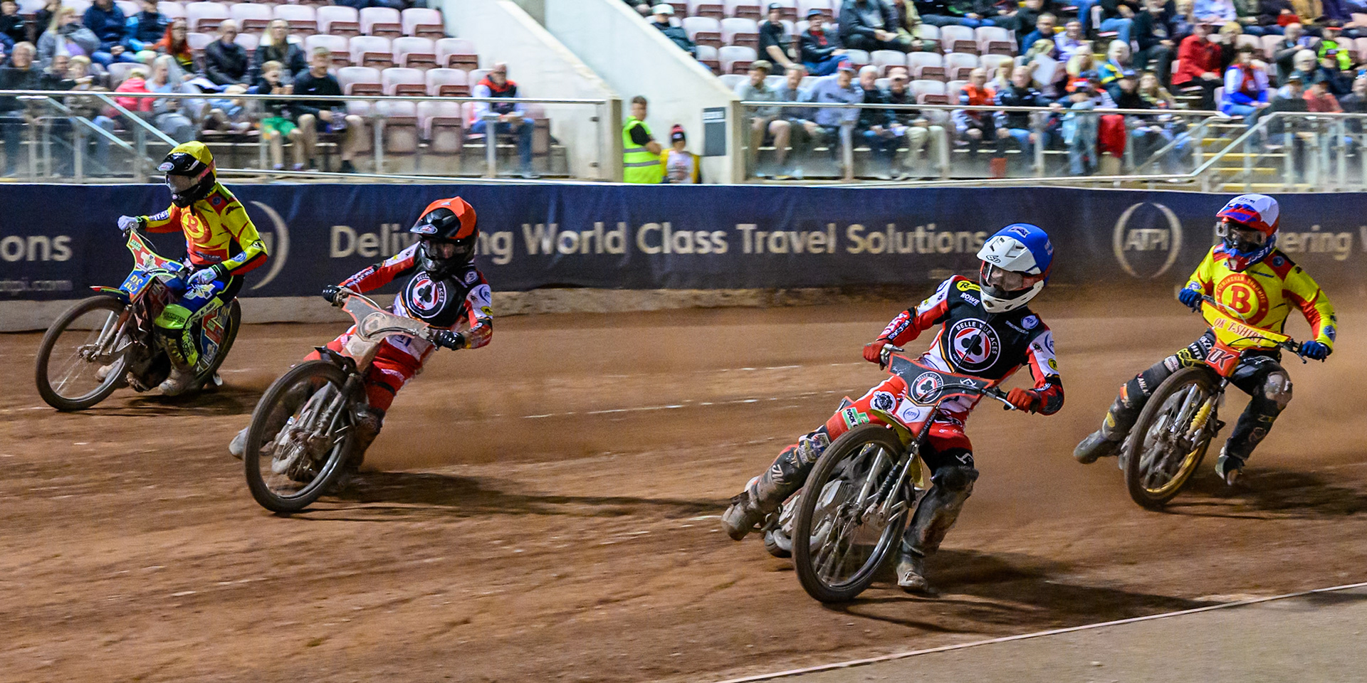 Tate Zischke of Belle Vue Aces  in Blue on the inside of Zach Cook of Belle Vue Aces  in Red and Simon Lambert, guest rider for Birmingham Brummies in Yellow with Paco Castagna of Birmingham Brummies  in White behind during the Rowe Motor Oil Premiership match between Belle Vue Aces and Birmingham Brummies at the National Speedway Stadium, Manchester on Monday 18th August 2025. (Photo: Ian Charles | MI News)
