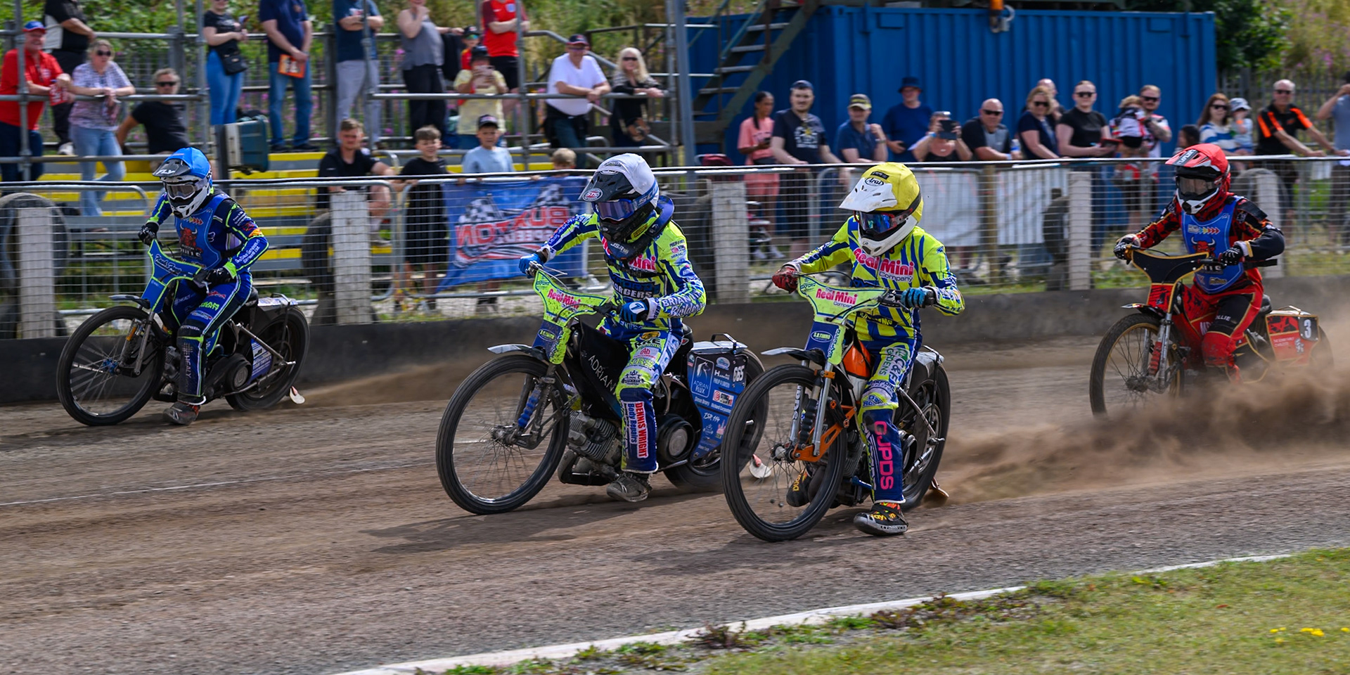 The second re-run of Heat 5: Arran Butcher of Buxton Bulls in Blue on the outside of Jody Scott of Oxford Chargers in White  and Harry Fletcher of Oxford Chargers in Yellow  with Luke Harris of Buxton Bulls in Red  behind during the WSRA National Development League match between Buxton Bulls and Oxford Chargers at Hi-Edge Speedway, Buxton on Sunday 2nd August 2026. (Photo: Ian Charles | MI News)