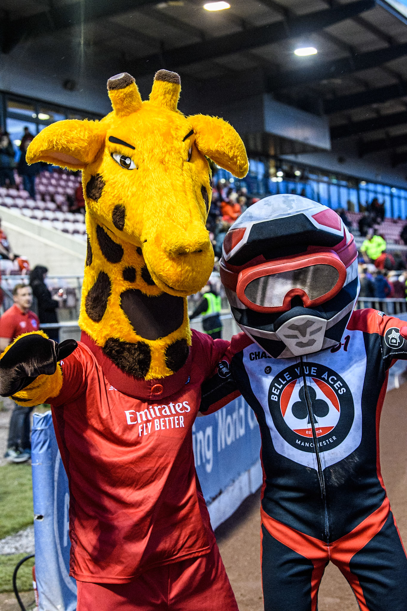 Belle Vue Aces mascot Chase The Ace (Right) meets Lancashire County Cricket Club Mascot Lanky The Giraffe during the Rowe Motor Oil Premiership match between Belle Vue Aces and Oxford Spires at the National Speedway Stadium, Manchester on Monday 13th May 2024. (Photo: Ian Charles | MI News)