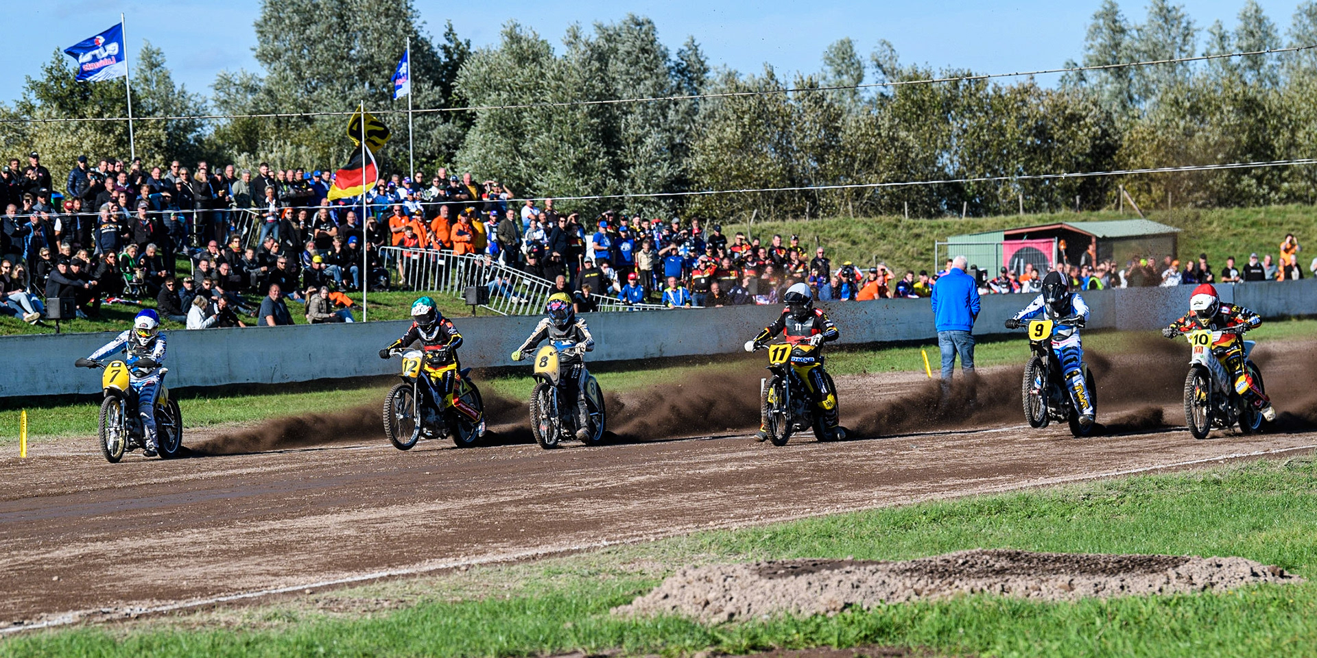 The opening heat as the riders leave the start  (L to R) Tero Aarnio (Blue), Jörg Tebbe (Green) Henri Ahlbom (Yellow) Erik Riss (White) Jesse Mustonen (Black &amp; White) Martin Smolinski (Red) during the FIM Long Track Of Nations event at the Speed Centre Roden on Sunday 24th September 2023. (Photo: Ian Charles | MI News)