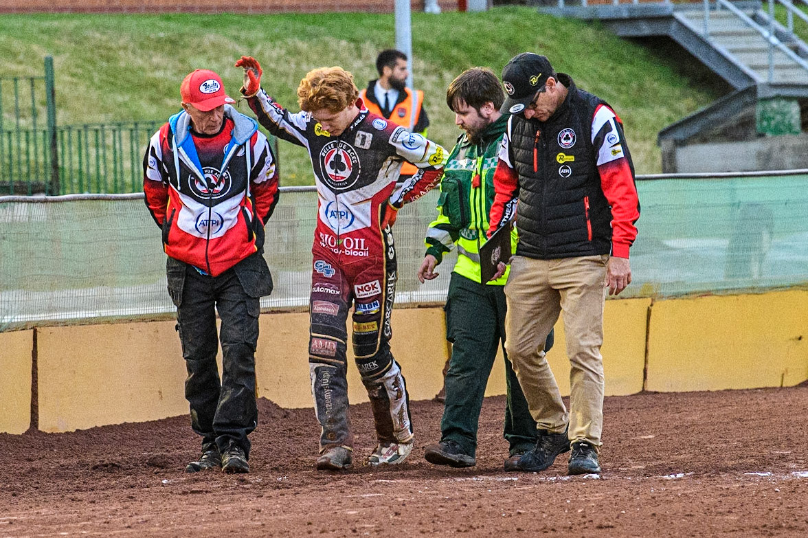 Dan Bewley (2nd left, waving) walks back to the pits after his fall with (l - r) Dad, Neil Bewley, Dan Bewley , Paramedic, \and team manager Mark Lemon during the Sports Insure Premiership match between Wolverhampton Wolves and Belle Vue Aces at Monmore Green Stadium, Wolverhampton on Monday 10th July 2023. (Photo: Ian Charles | MI News)