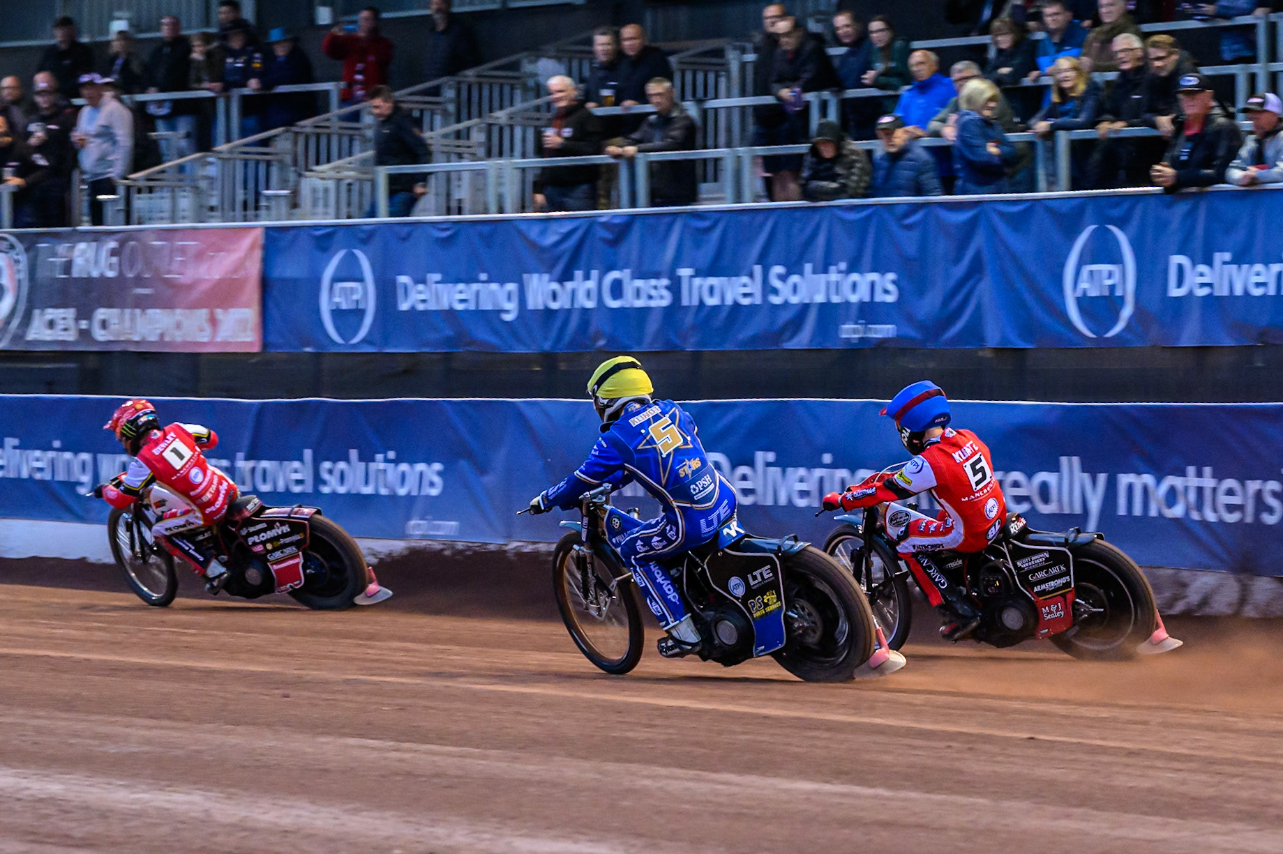 Kings Lynn Stars' Nicolai Klindt in Yellow on the inside of Belle Vue Aces' Brady Kurtz in Blue as they chase Belle Vue Aces' Dan Bewley in Red during the Rowe Motor Oil Premiership match between Belle Vue Aces and King's Lynn Stars at the National Speedway Stadium, Manchester on Monday 23rd June 2025. (Photo: Ian Charles | MI News)