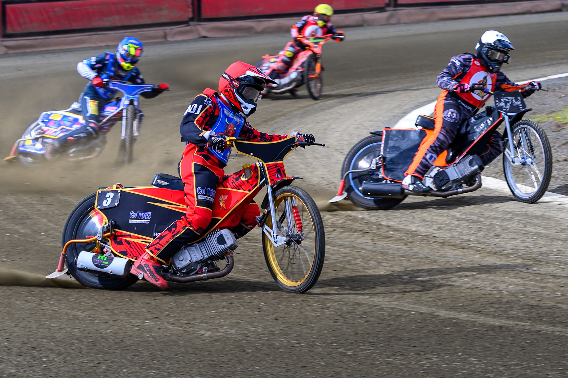 Luke Harris of Buxton Bulls   in Red rides outside Jack Roberts of NDL Nomads  in White with Jamie Etherington of Buxton Bulls in Blue and Alex Spooner of NDL Nomads   in Yellow behind during the  Challenge match between Buxton Bulls and NDL Nomads at Hi-Edge Speedway, Buxton on Sunday 19th April 2026. (Photo: Ian Charles | MI News)