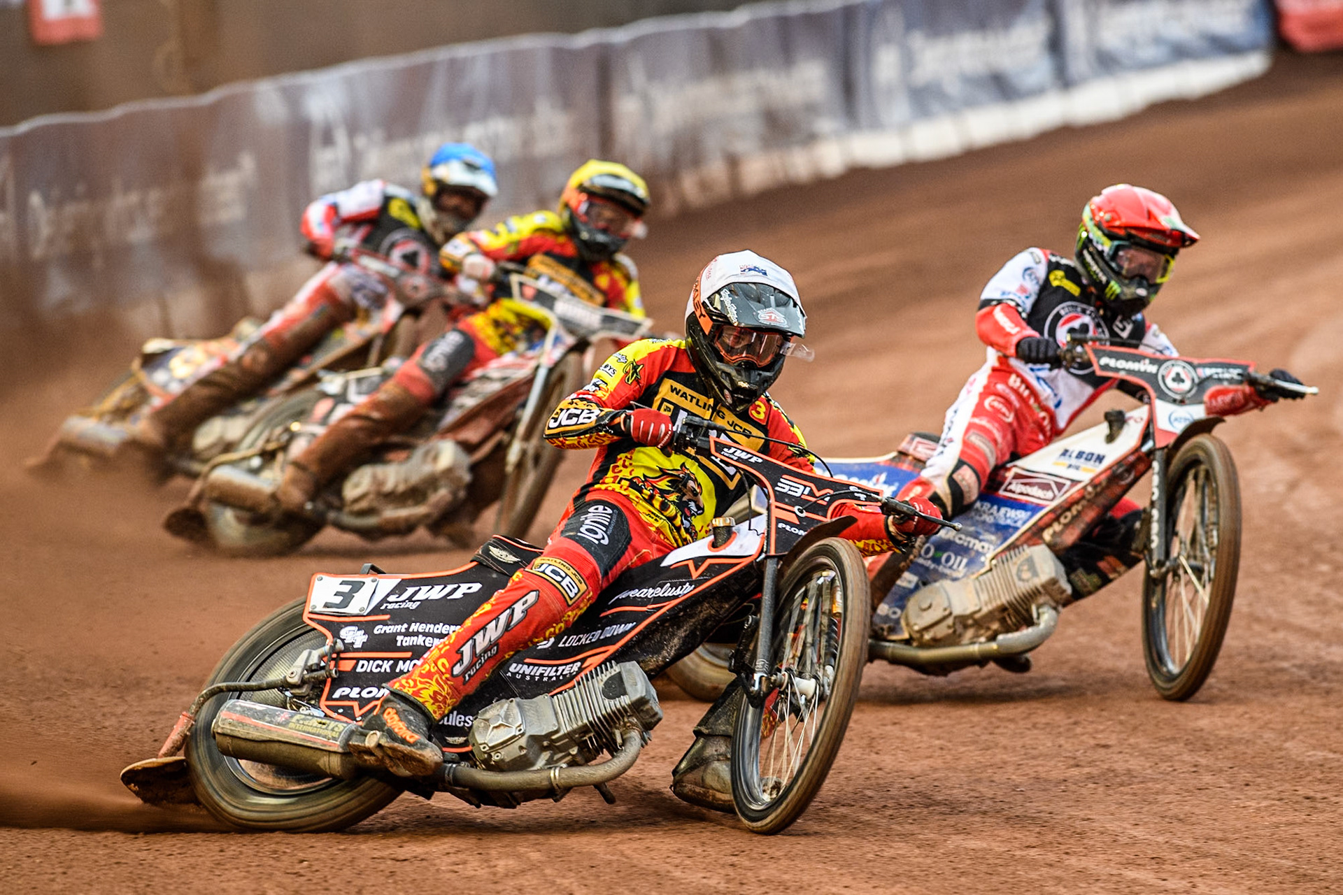 Leicester Lions' Sam Masters in White rides outside Belle Vue Aces' Dan Bewley in Red with Leicester Lions' Luke Becker in Yellow and Belle Vue Aces' Connor Mountain in Blue behind during the Rowe Motor Oil Premiership match between Belle Vue Aces and Leicester Lions at the National Speedway Stadium, Manchester on Monday 24th June 2024. (Photo: Ian Charles | MI News)