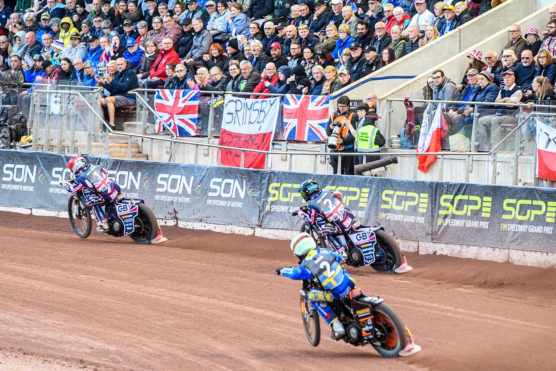 Jacob Thorssell of Sweden in Yellow chases Dan Bewley of Great Britain in Blue and Robert Lambert of Great Britain in Red during the Monster Energy FIM Speedway of Nation Final at the National Speedway Stadium, Manchester on Saturday 13th July 2024. (Photo: Ian Charles | MI News)