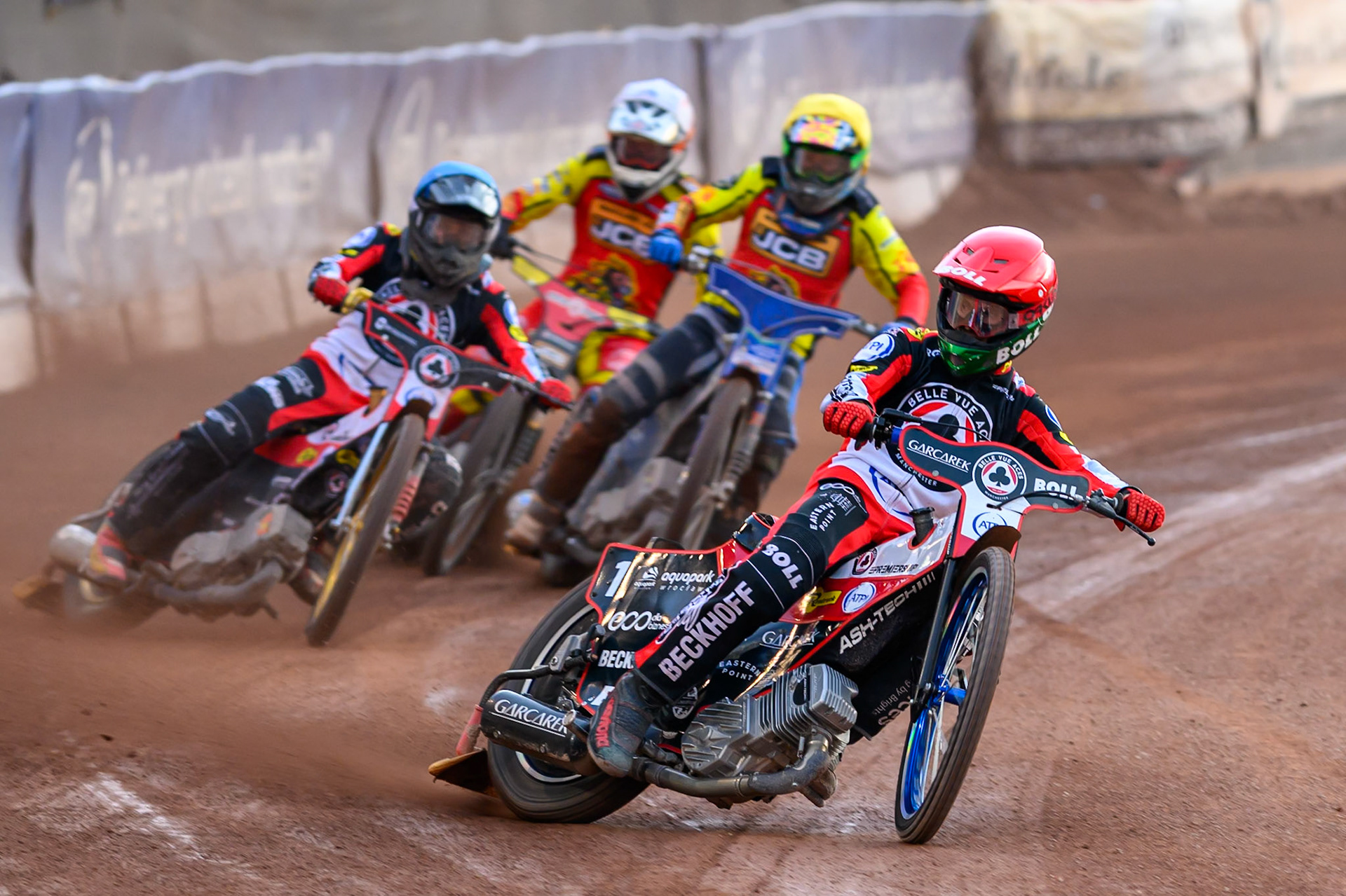 Brady Kurtz of Belle Vue Aces in Red leading Norick Blödorn of Belle Vue Aces in Blue , Jonas Jeppesen Guest rider for Leicester Lions in Yellow and Sam Masters of Leicester Lions in White during the Rowe Motor Oil Premiership match between Belle Vue Aces and Leicester Lions at the National Speedway Stadium, Manchester on Monday 3rd August 2026. (Photo: Ian Charles | MI News)