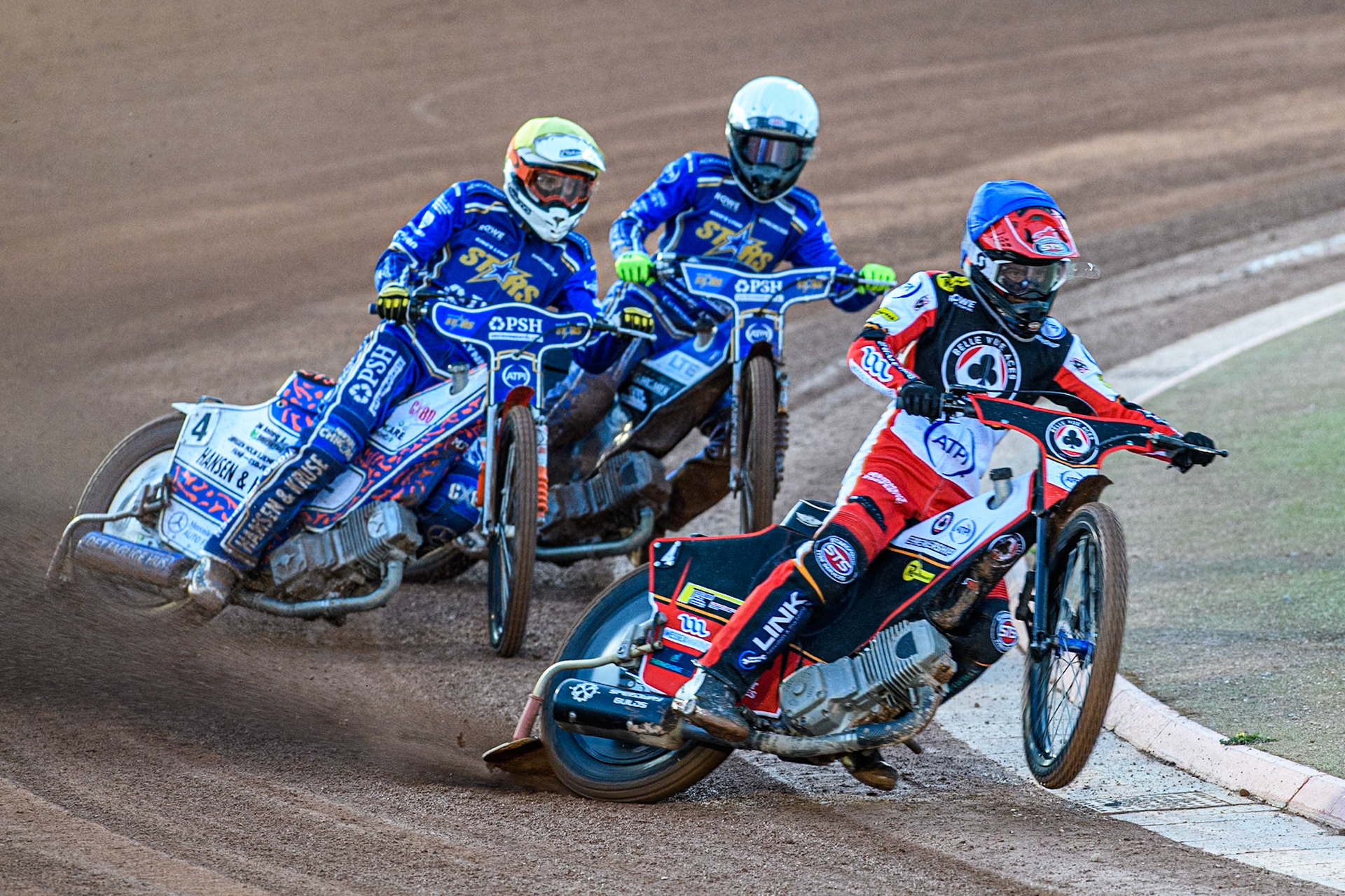 Zach Cook of Belle Vue Aces in Blue picks up some drive ahead of Niels-Kristian Iversen of Kings Lynn Stars in Yellow and Nicolai Klindt of Kings Lynn Stars in White during the Rowe Motor Oil Premiership match between Belle Vue Aces and King's Lynn Stars at the National Speedway Stadium, Manchester on Monday 5th April 2025. (Photo: Ian Charles | MI News)