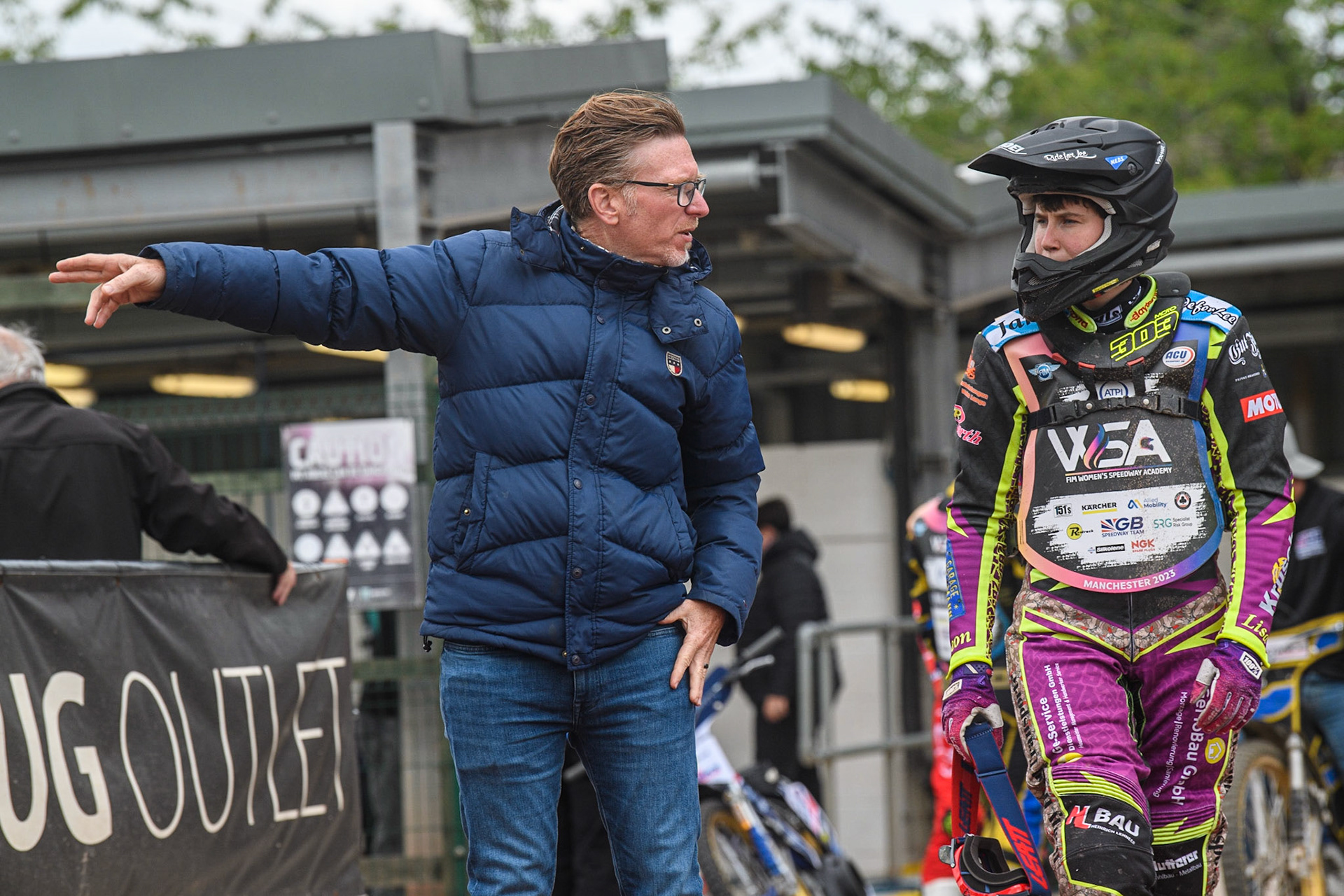 Three time World Speedway Champion Jason Crump (left) points out the line to take on track to Celina Liebmann  during the FIM Women's  Speedway Academy at the National Speedway Stadium, Manchester on Friday 4th August 2023. (Photo: Ian Charles | MI News)