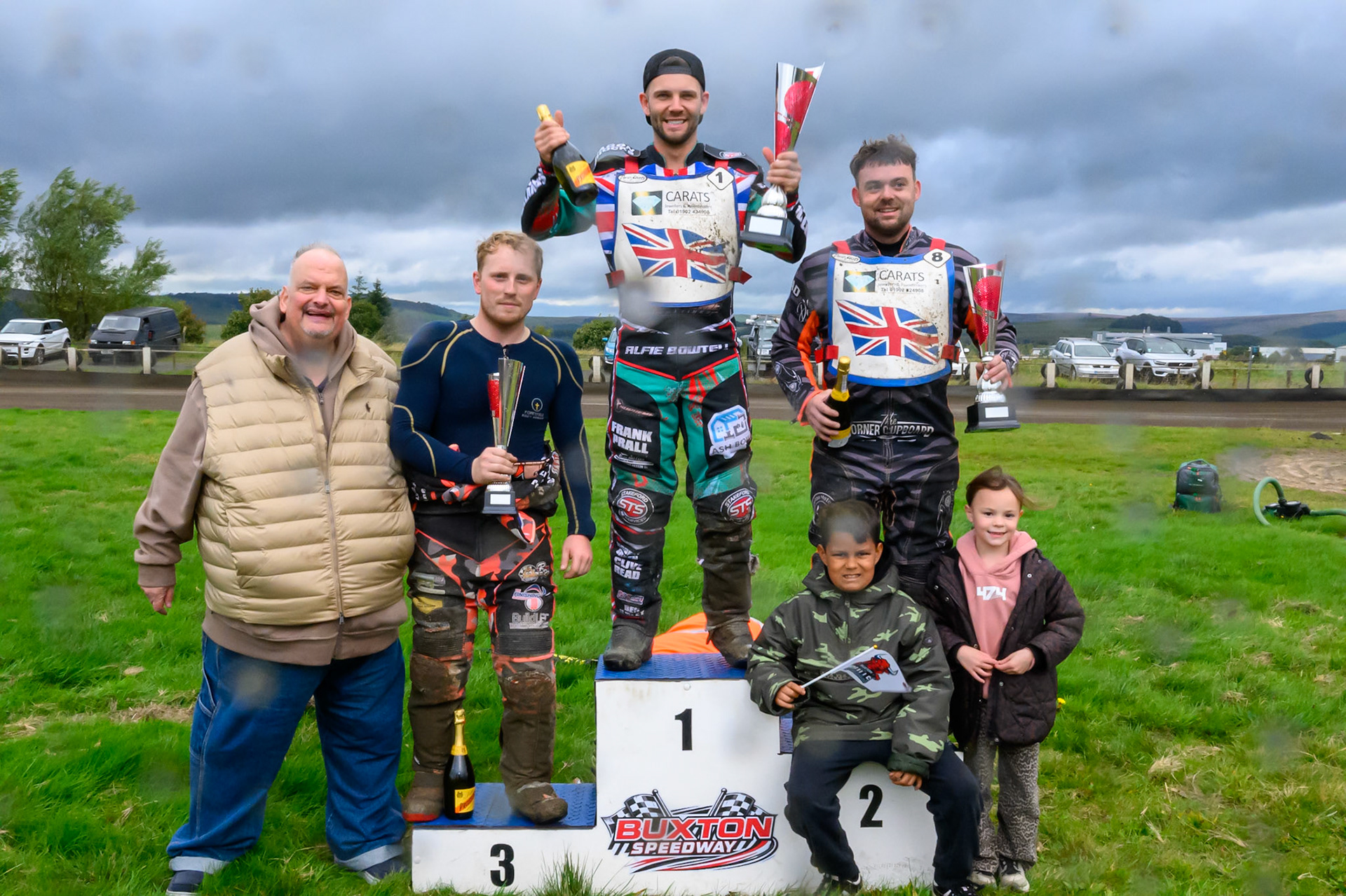 The Rostrum: (L to R) Blayne Scroggins (Meeting Sponsor), Alex Spooner (3rd), Alfie Bowtell (Winner) and Jack Roberts  (2nd) with Jacks Children in the foreground during the Derbyshire Open at Hi-Edge Speedway, Buxton on Sunday 27th September 2026. (Photo: Ian Charles | MI News)