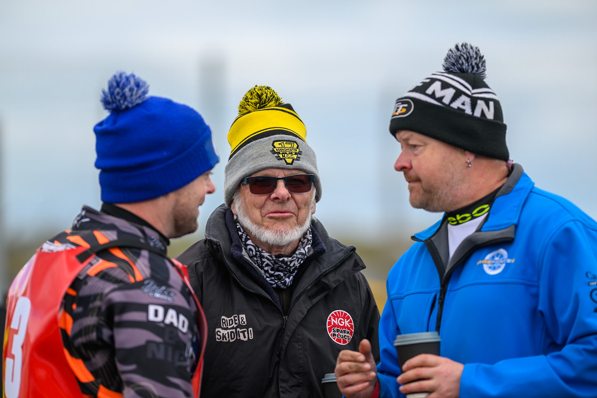 Jack Roberts of NDL Nomads  (Left) chats with former rider Ken Eyre (Centre) and his son, the British Flat Track champion, Toby Eyre during the  Challenge match between Buxton Bulls and NDL Nomads at Hi-Edge Speedway, Buxton on Sunday 19th April 2026. (Photo: Ian Charles | MI News)