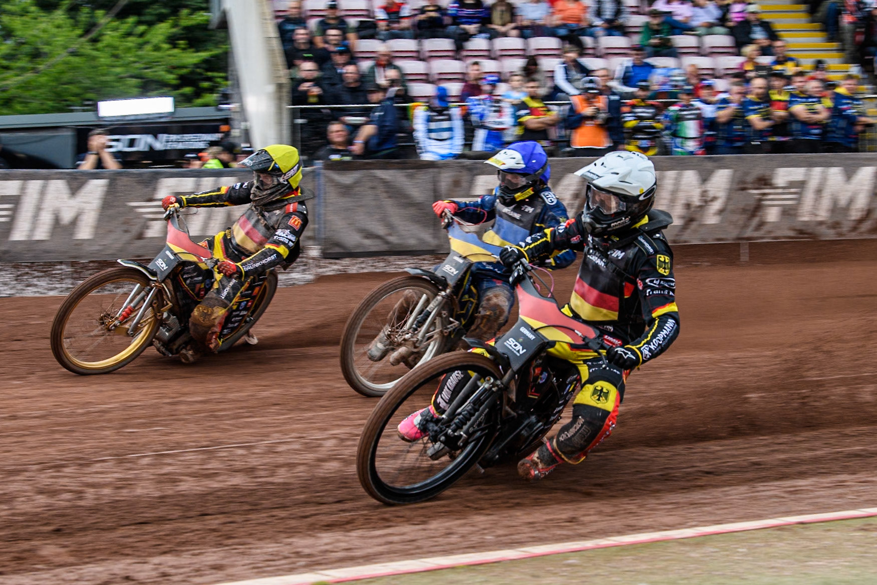 Ukraine v Germany: Kai Huckenbeck of Germany in White rides inside Marko Levishyn of Ukraine in Blue and Norick Blödorn of Germany in Yellow  during the Monster Energy FIM Speedway of Nations Semi-Final 1 at the National Speedway Stadium, Manchester on Tuesday 9th July 2024. (Photo: Ian Charles | MI News)