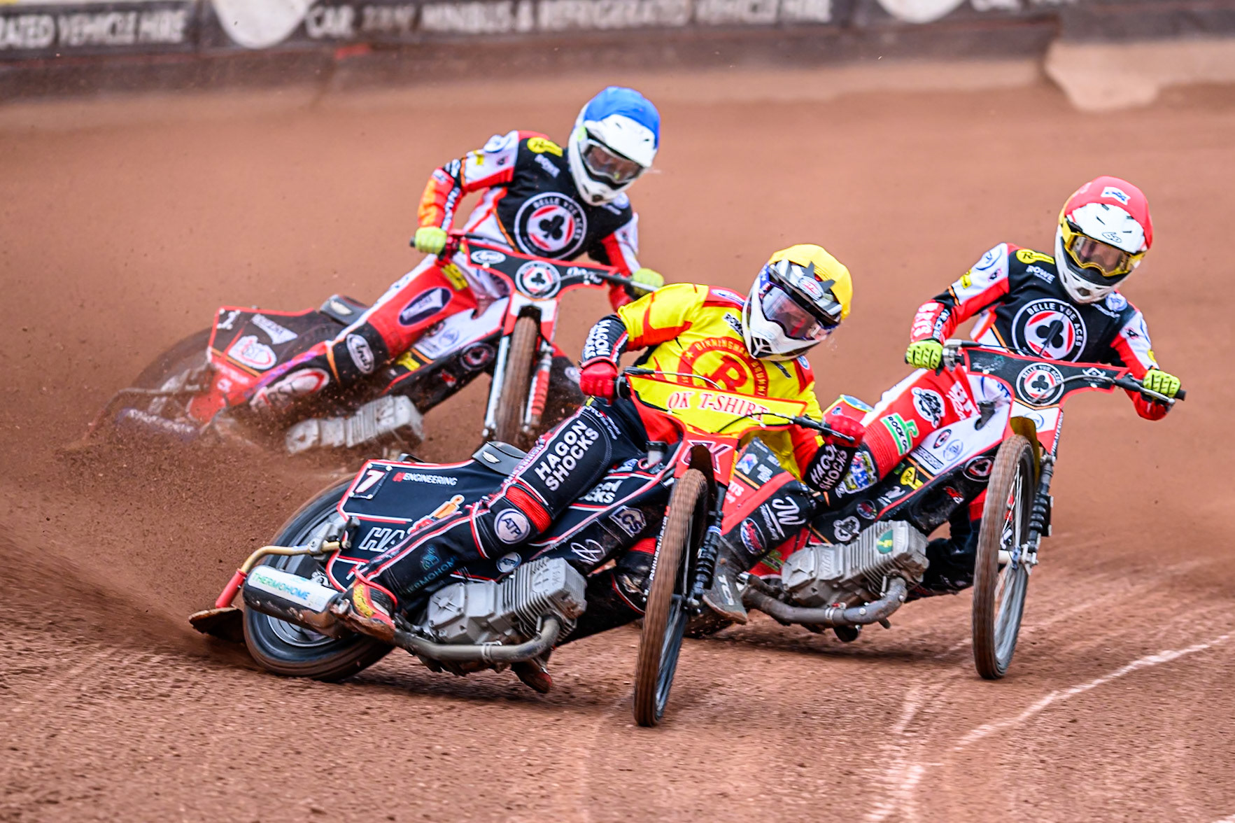Birmingham Brummies' Sam Hagon  in Yellow leading Belle Vue Aces' Tate Zischke  in Red and Belle Vue Aces' Jake Mulford  in Blue during the Rowe Motor Oil Premiership match between Belle Vue Aces and Birmingham Brummies at the National Speedway Stadium, Manchester on Monday 7th July 2025. (Photo: Ian Charles | MI News)