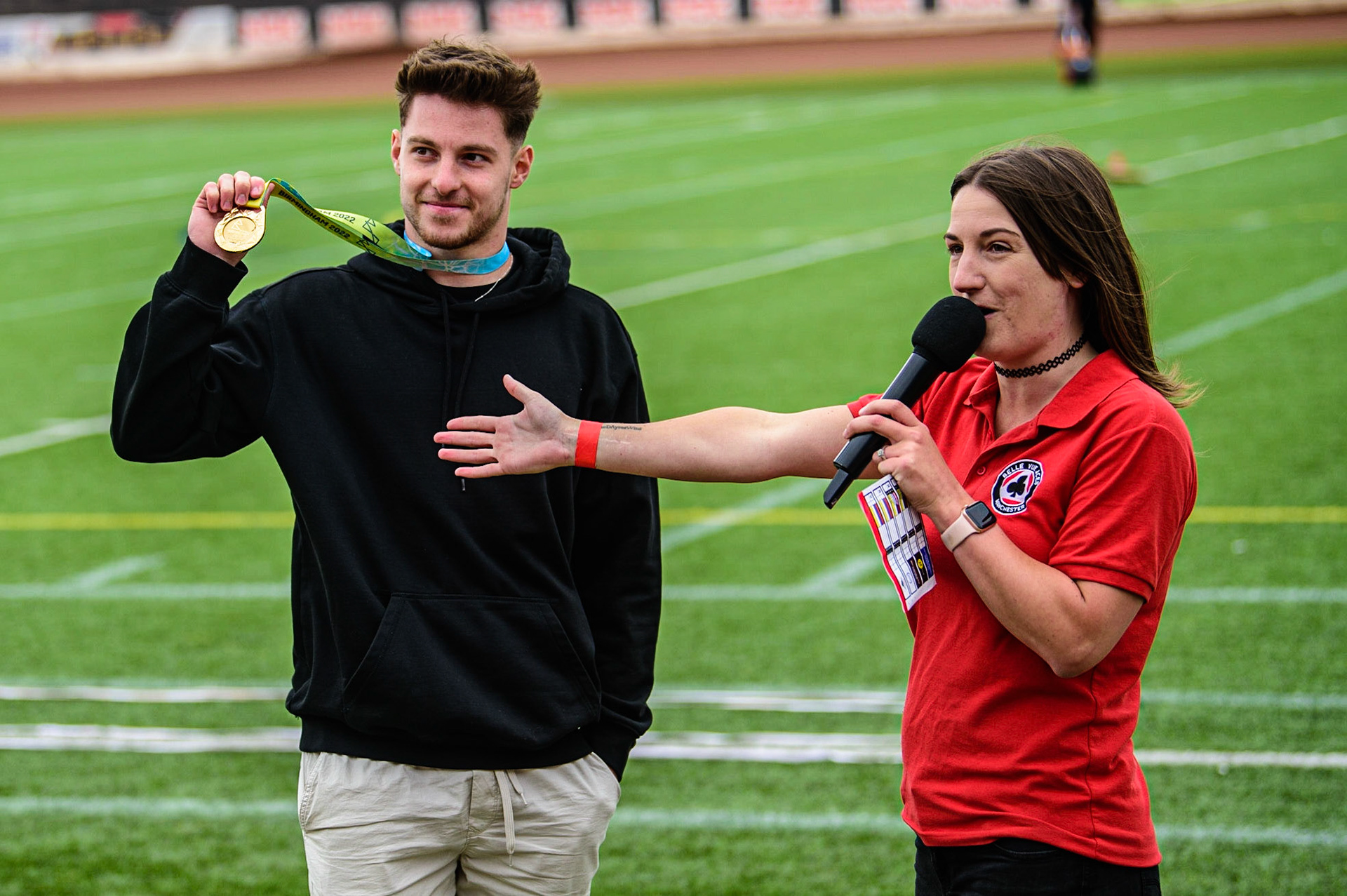 Meeting presenter Hayley Bromley (right) introduces Commonwealth Gold Synchro Divining Gold Medal winner Anthony Harding to the fans.Harding is a Belle Vue Aces supporter, who attends when his training permits,  during the SGB Premiership match between Belle Vue Aces and Wolverhampton Wolves at the National Speedway Stadium, Manchester on Monday 29th August 2022. (Credit: Ian Charles | MI News)