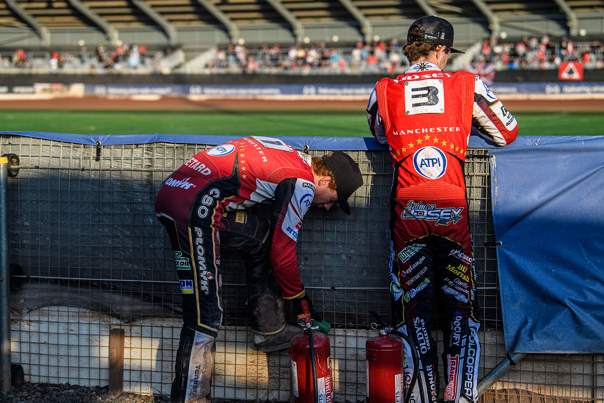 Dan Bewley (left) cleans off his kevlars, as Jaimon Lidsey watches the track prep during the Sports Insure Premiership match between Belle Vue Aces and Peterborough at the National Speedway Stadium, Manchester on Monday 19th June 2023. (Photo: Ian Charles | MI News)
