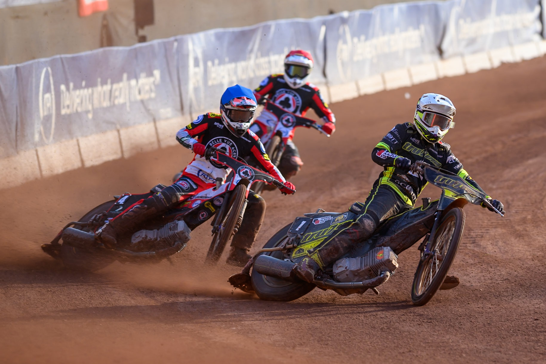 Tom Brennan of Ipswich Witches in White leading Peter Kildemand of Belle Vue Aces in Red and Zach Cook of Belle Vue Aces in Blue during the Rowe Motor Oil Premiership match between Belle Vue Aces and Ipswich Witches at the National Speedway Stadium, Manchester on Saturday 20th June 2026. (Photo: Ian Charles | MI News)