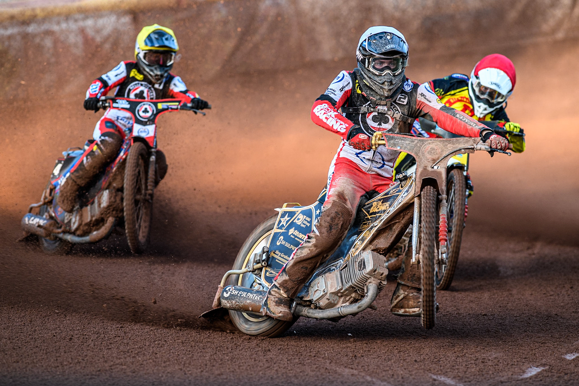 Belle Vue Aces' Norick Blodorn in White picks up some drive leading Birmingham Brummies' Wiktor Lampart in Red and Belle Vue Aces' Ben Cook in Yellow during the Rowe Motor Oil Premiership match between Birmingham Brummies and Belle Vue Aces at Perry Bar Stadium, Birmingham on Monday 29th July 2024. (Photo: Ian Charles | MI News)