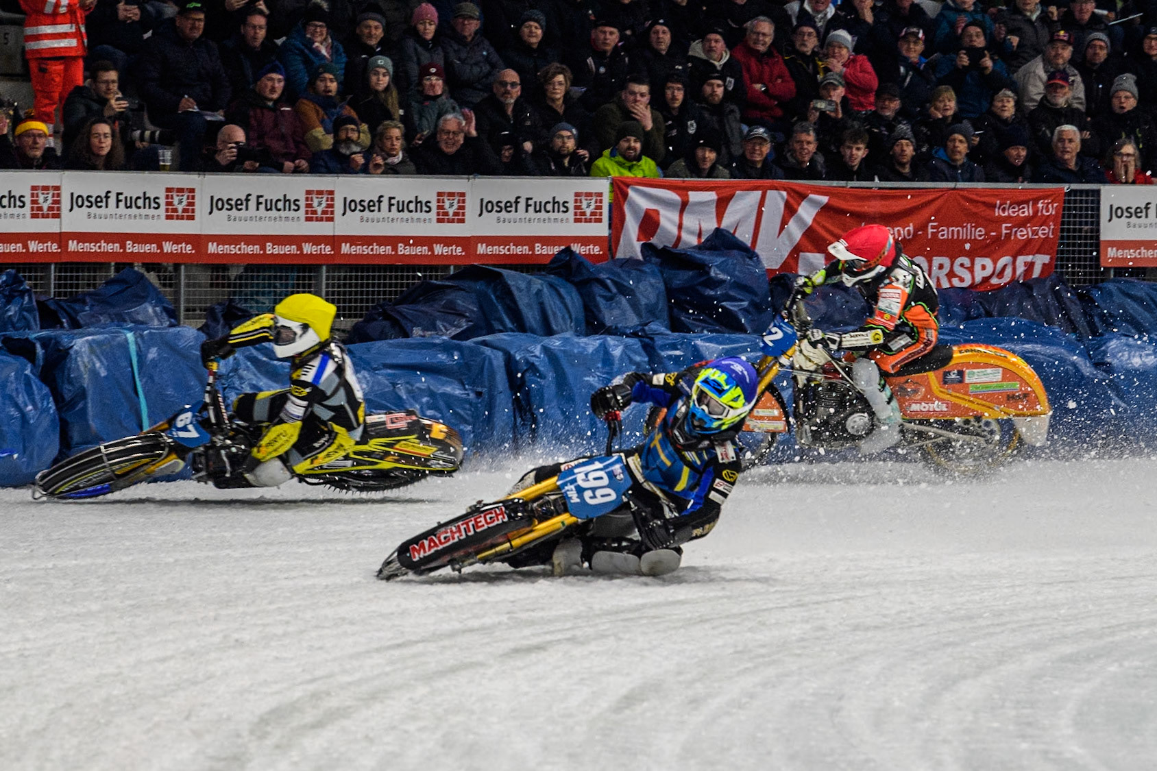 Sweden's Martin Haarahiltunen (199)  (Blue) leads  and Germany's Markus Jell (82) (Red) and Finland's Heikki Huusko (67)y\ collide and crash into the bales during the FIM Ice Speedway Gladiators World Championship Final 2 at the Max-Aicher-Arena, Inzell on Sunday 24 March 2024. (Photo: Ian Charles | MI News)