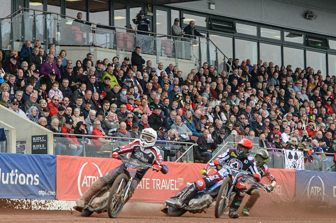 MANCHESTER, UK. MAY 2ND A full house at the National Speedway Stadium watches Ulrich Ostergaard  (White) lead Matej Žagar  (Red) and Benjamin Basso (Yellow)   during the SGB Premiership match between Belle Vue Aces and Peterborough at the National Speedway Stadium, Manchester on Monday 2nd May 2022. (Credit: Ian Charles | MI News)