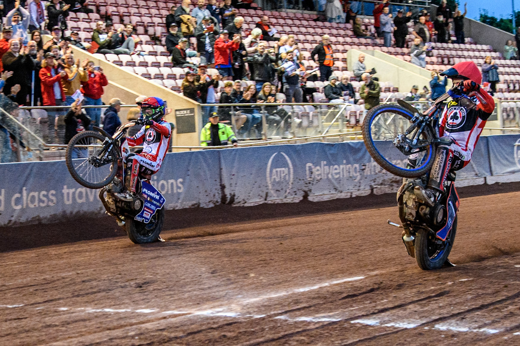 Belle Vue Aces' Brady Kurtz in Red and Belle Vue Aces' Dan Bewley  in Blue celebrate with wheelies during the Rowe Motor Oil Premiership match between Belle Vue Aces and Oxford Spires at the National Speedway Stadium, Manchester on Monday 22nd July 2024. (Photo: Ian Charles | MI News)