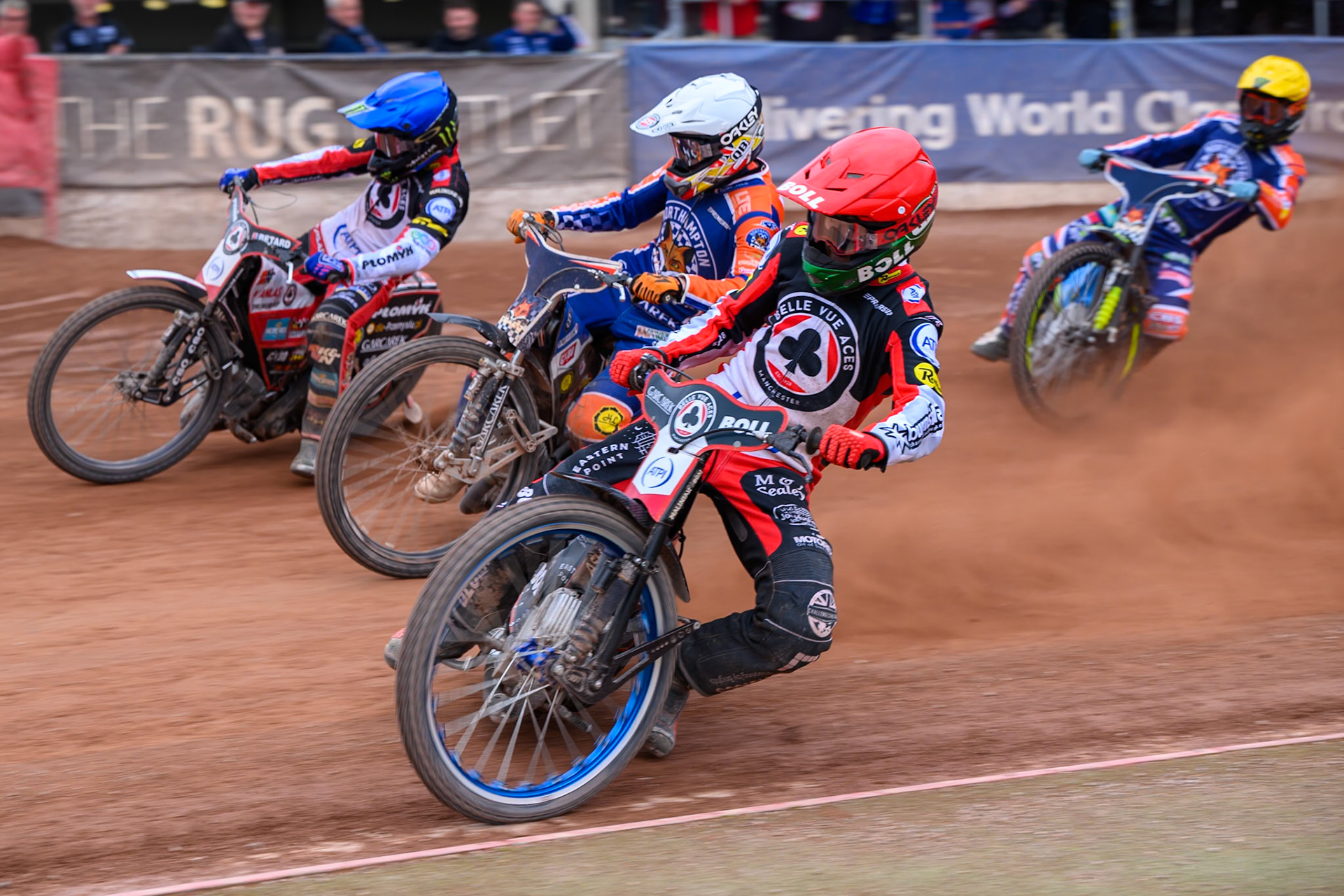 Brady Kurtz of Belle Vue Aces  in Red rides inside Nicolai Klindt of Northampton Foxes  in White and Dan Bewley of Belle Vue Aces in Blue with Jaimon Lidsey of Northampton Foxes  in Yellow behind during the Rowe Motor Oil Premiership match between Belle Vue Aces and Northampton Foxes at the National Speedway Stadium, Manchester on Monday 4th May 2026. (Photo: Ian Charles | MI News)