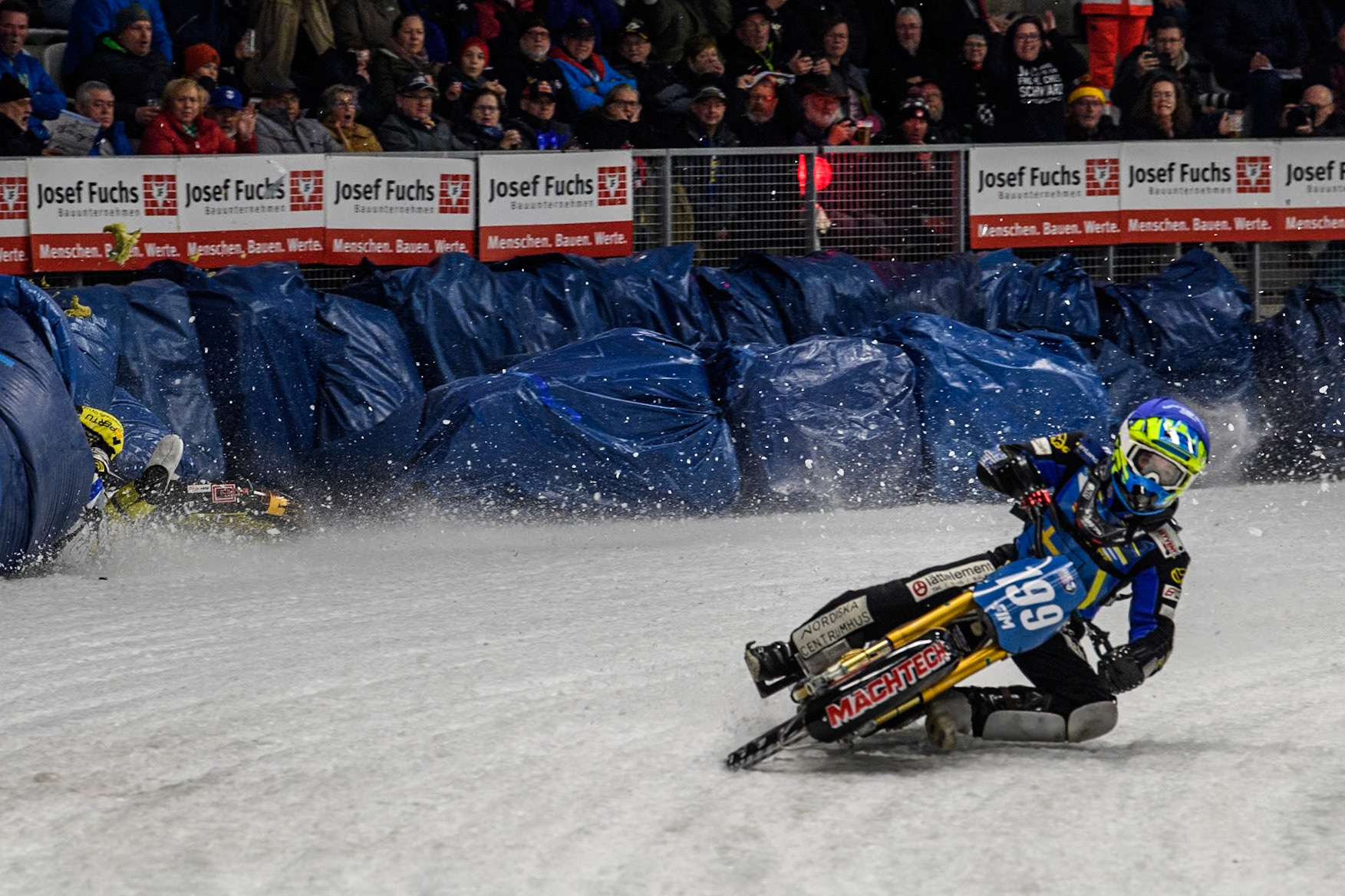 Sweden's Martin Haarahiltunen (199)  (Blue) leads  and Germany's Markus Jell (82) (Red) and Finland's Heikki Huusko (67)y\ collide and crash into the bales during the FIM Ice Speedway Gladiators World Championship Final 2 at the Max-Aicher-Arena, Inzell on Sunday 24 March 2024. (Photo: Ian Charles | MI News)