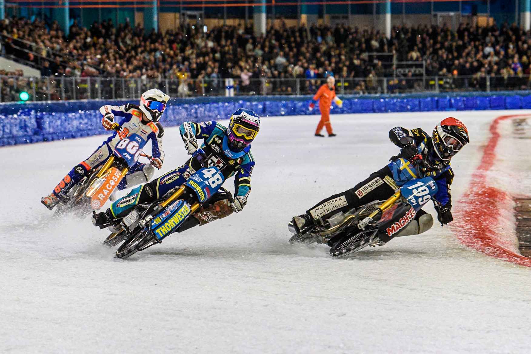 Martin Haarahiltunen (199) of Sweden in Red rides inside Luca Bauer (48) of Germany in Blue ahead of Jasper Iwema (800) of The Netherlands in White during the FIM Ice Speedway Gladiators World Championship, Final 3 at the Ice Stadium, Thialf, Heerenveen on Saturday 5th April 2025. (Photo: Ian Charles | MI News)